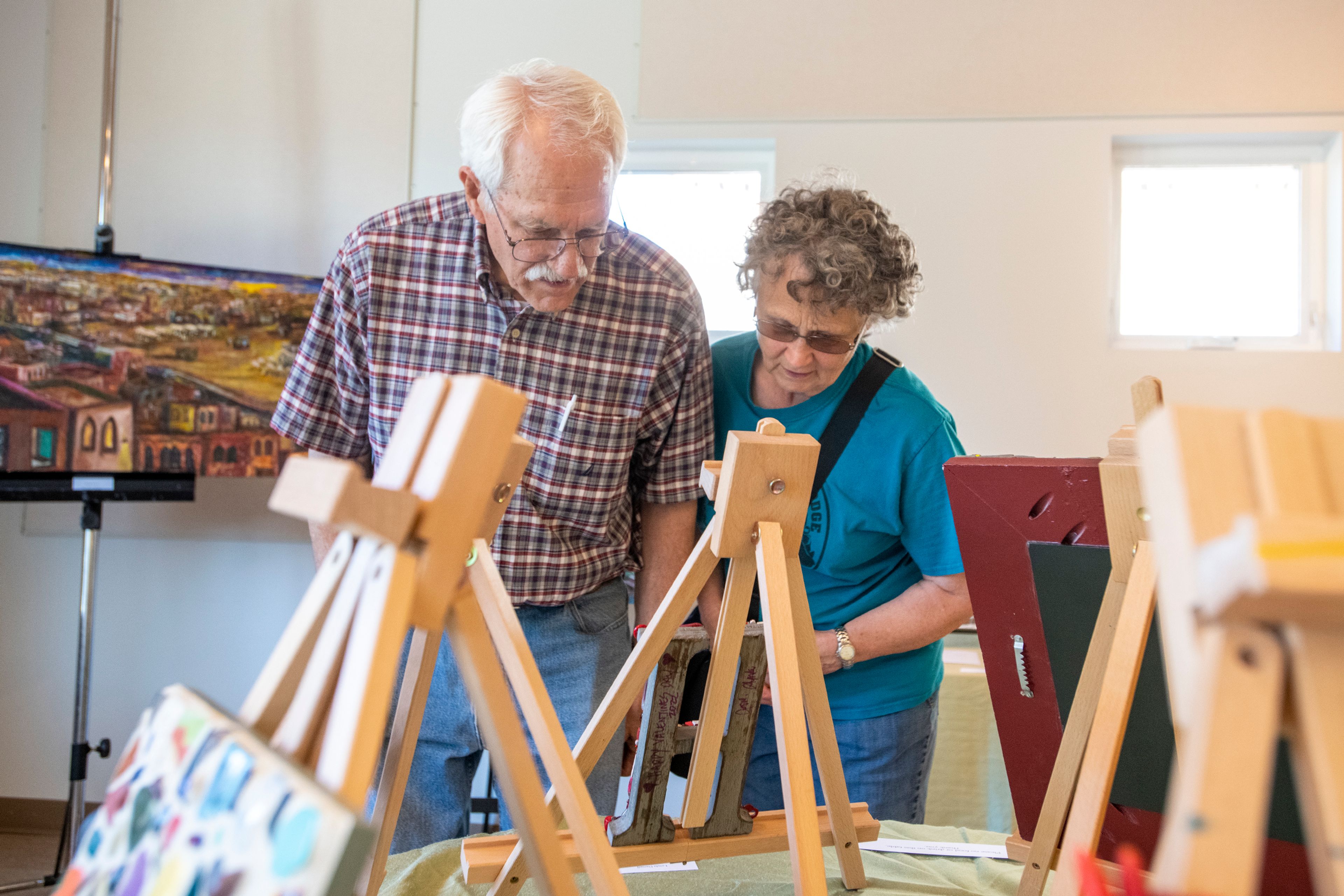 Zach Wilkinson/Daily NewsErin Talbott, left, and his wife, Toni, both of Palouse, glance at some of the local artwork on display at the Palouse Community Center.