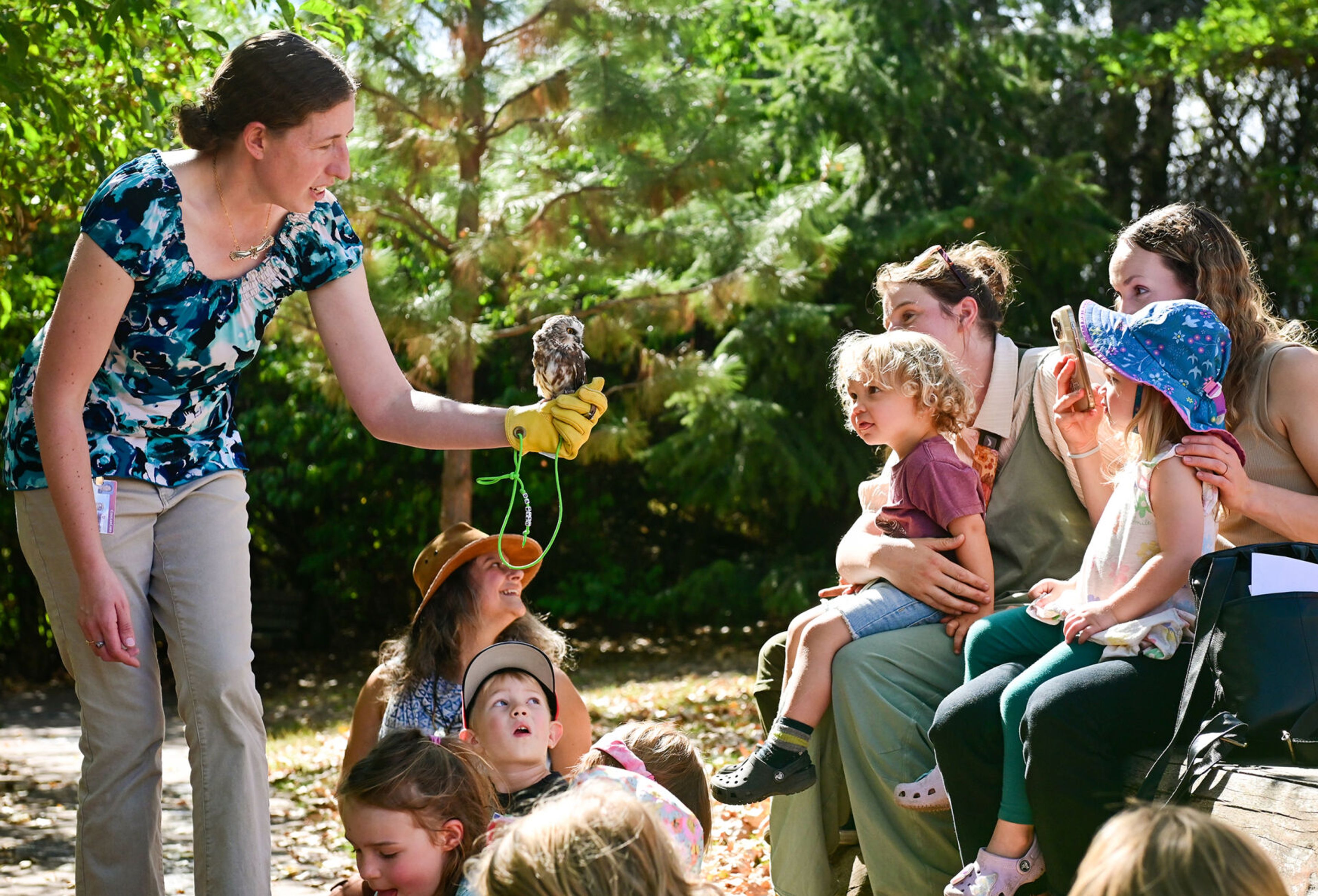 Marcie Logsdon, left, a professor and wildlife veterinarian at Washington State University, carries Sawyer, a Northern saw-whet owl, to members of Palouse Roots, Palouse-Clearwater Environmental Institute’s nature school, before the release of a Western screech owl at the nature center Thursday in Moscow.