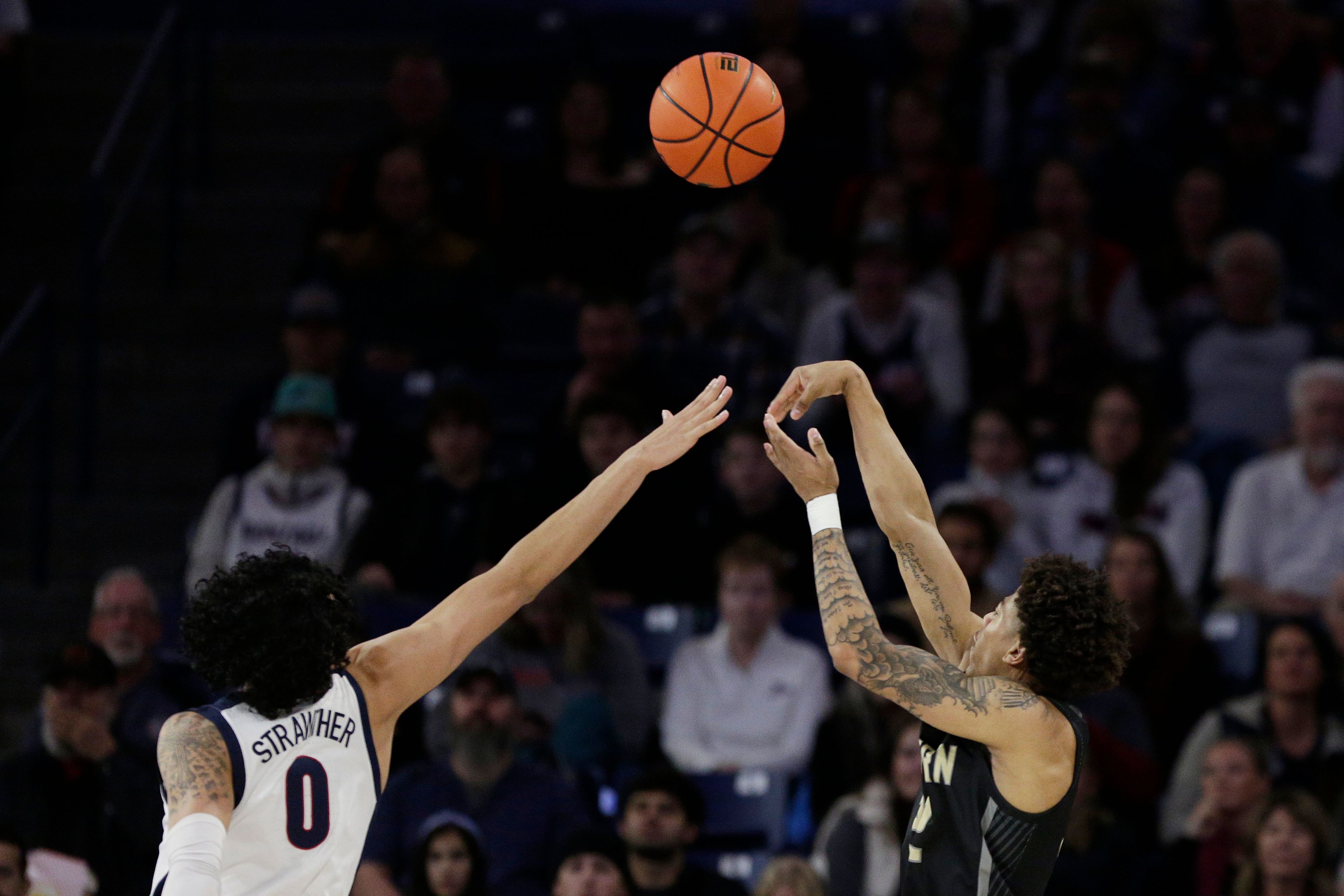 Eastern Oregon guard AJ Huddleston, right, shoots while defended by Gonzaga guard Julian Strawther during the first half of a college basketball game, Wednesday, Dec. 28, 2022, in Spokane, Wash. (AP Photo/Young Kwak)