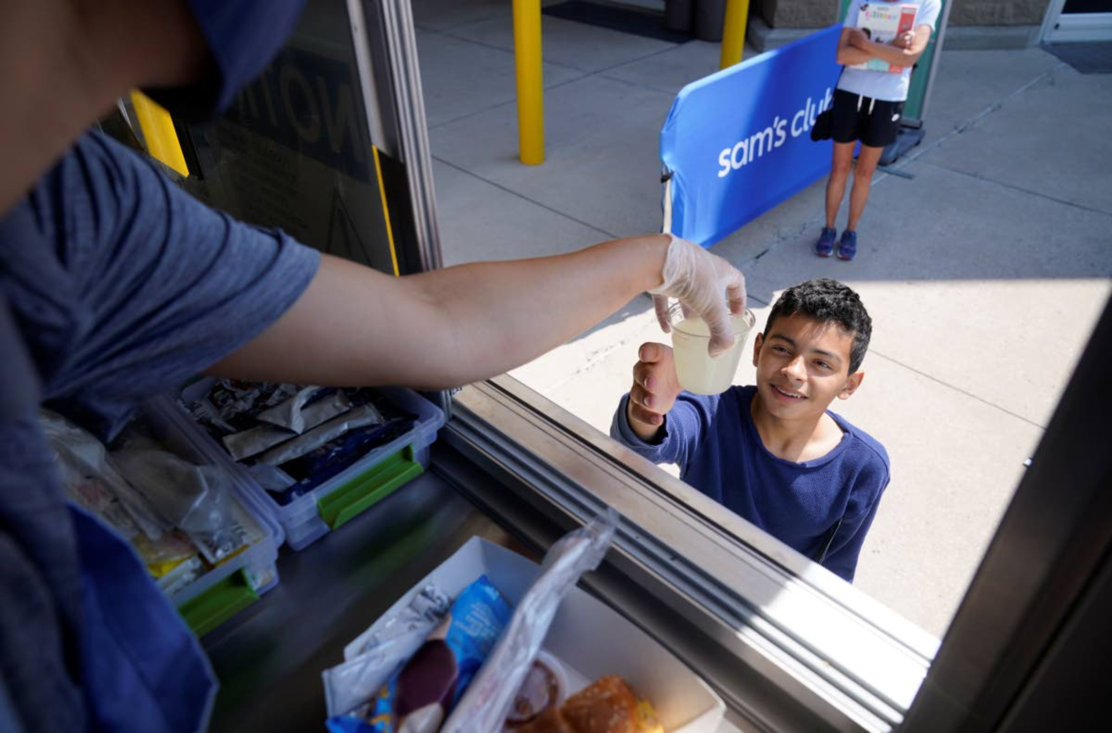 Tiffany Sawczenko hands a drink sample to Michael, no last name given, out of a food truck window Friday, June 18, 2021, in McKinney, Texas. When the pandemic was declared in March 2020, retailers worried about the potential spread of the coronavirus so they cut off free sampling of everything from food to makeup to toys. But now with vaccinations rolling out and the threat of COVID-19 easing in the U.S., food vendors and stores are feeling confident enough to revive the longstanding tradition. (AP Photo/LM Otero)