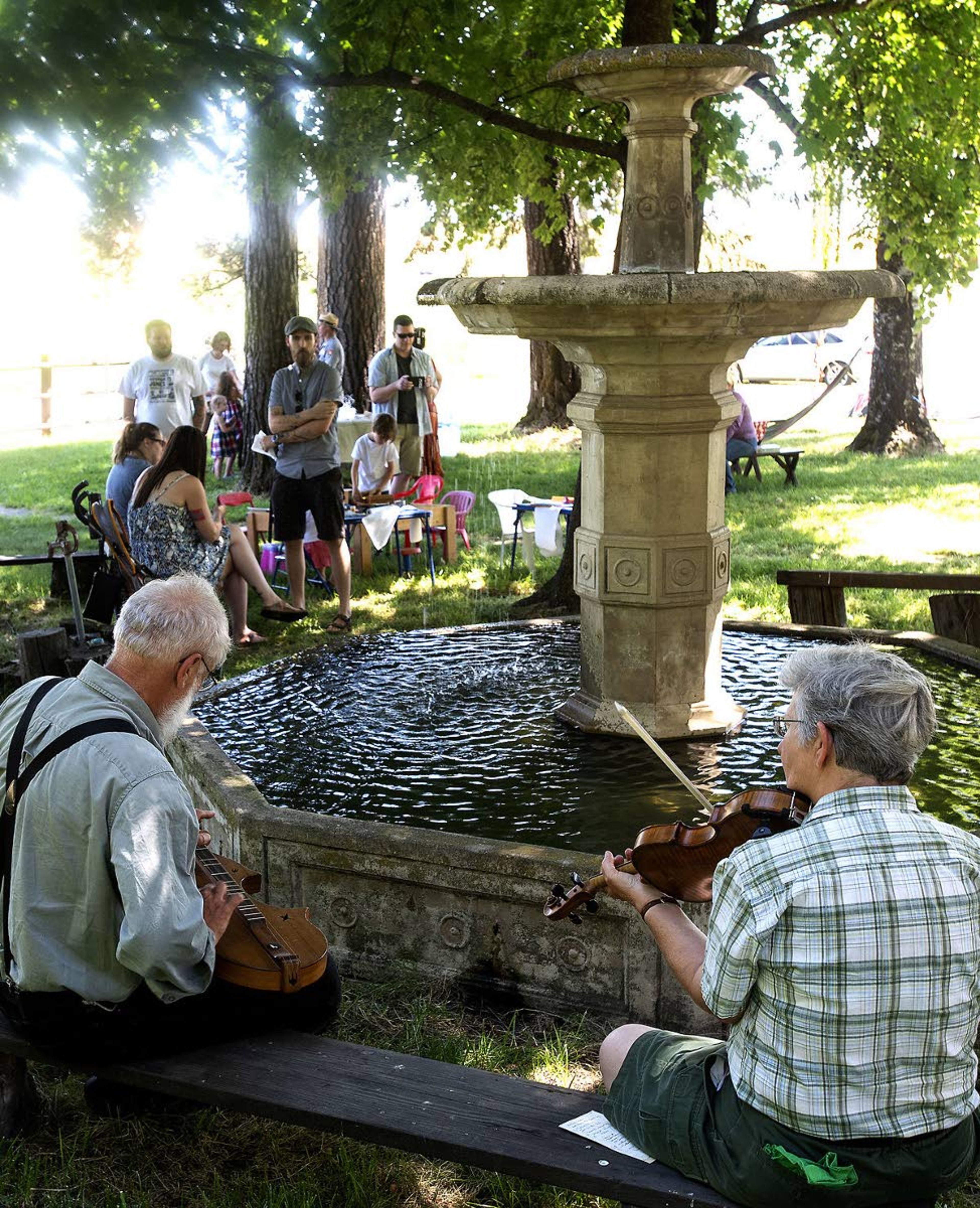 John Elwood, of Elberton, Wash., left, plays the dulcimer while Marsha Schoeffler, of Kendrick, performs on the fiddle at an ice cream social Aug. 1, 2018, at the White Spring Ranch outside Genesee.