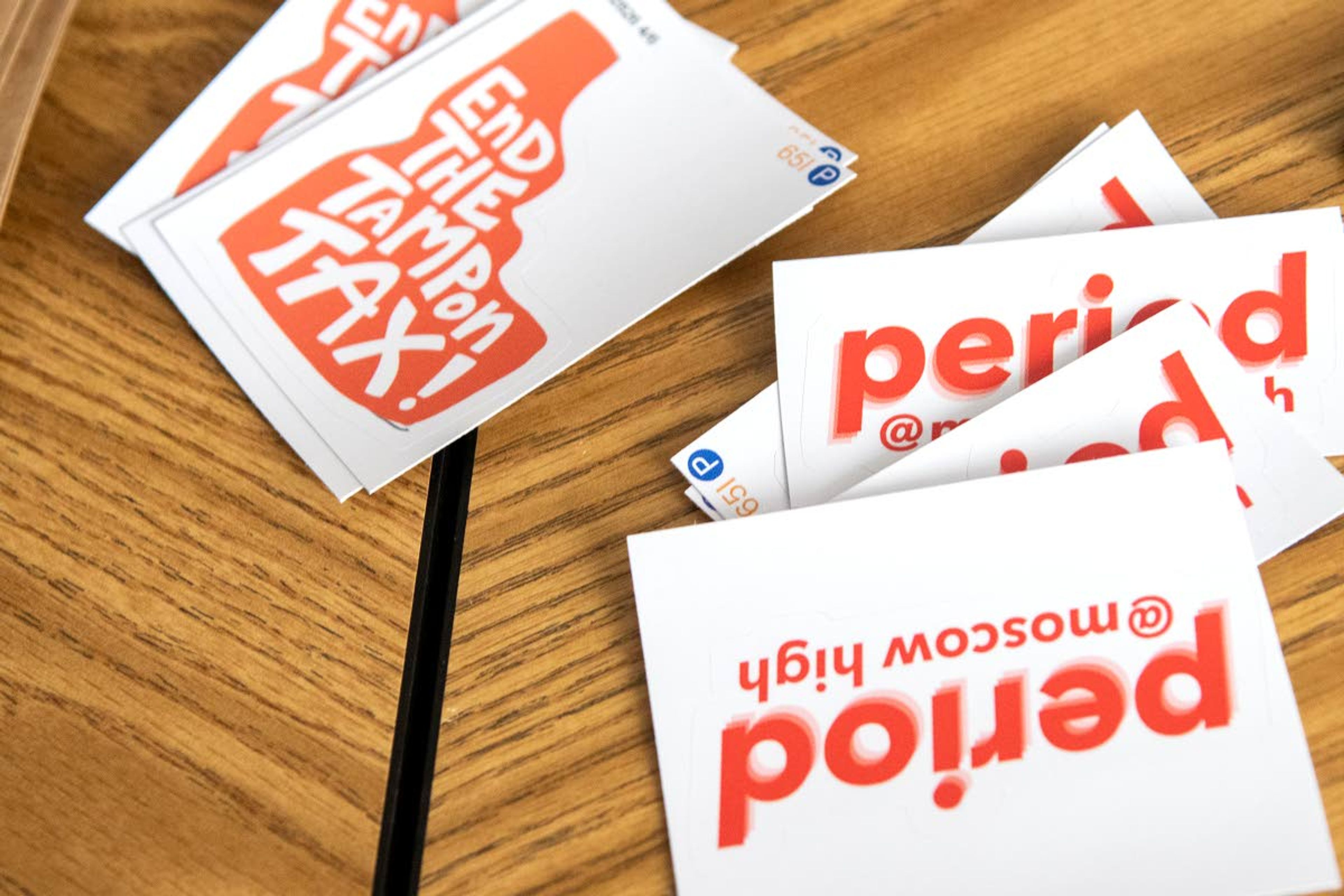 Stickers for members of “PERIOD: The Menstrual Movement,” are displayed on a table while they package period product supplies at Moscow High School on Wednesday afternoon.