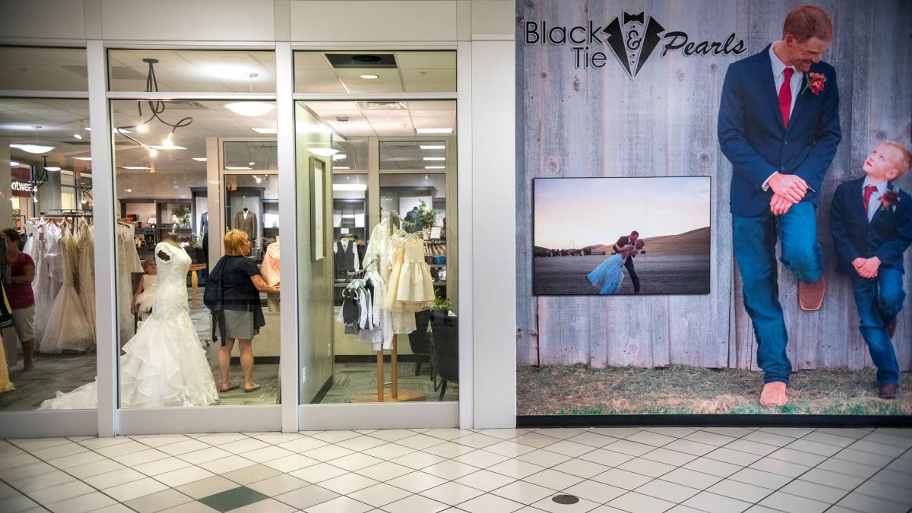 Owner Valerie Mesenbrink, center, assists a customer in finding a dress at Black Tie and Pearls inside the Palouse Mall on Thursday afternoon in Moscow.