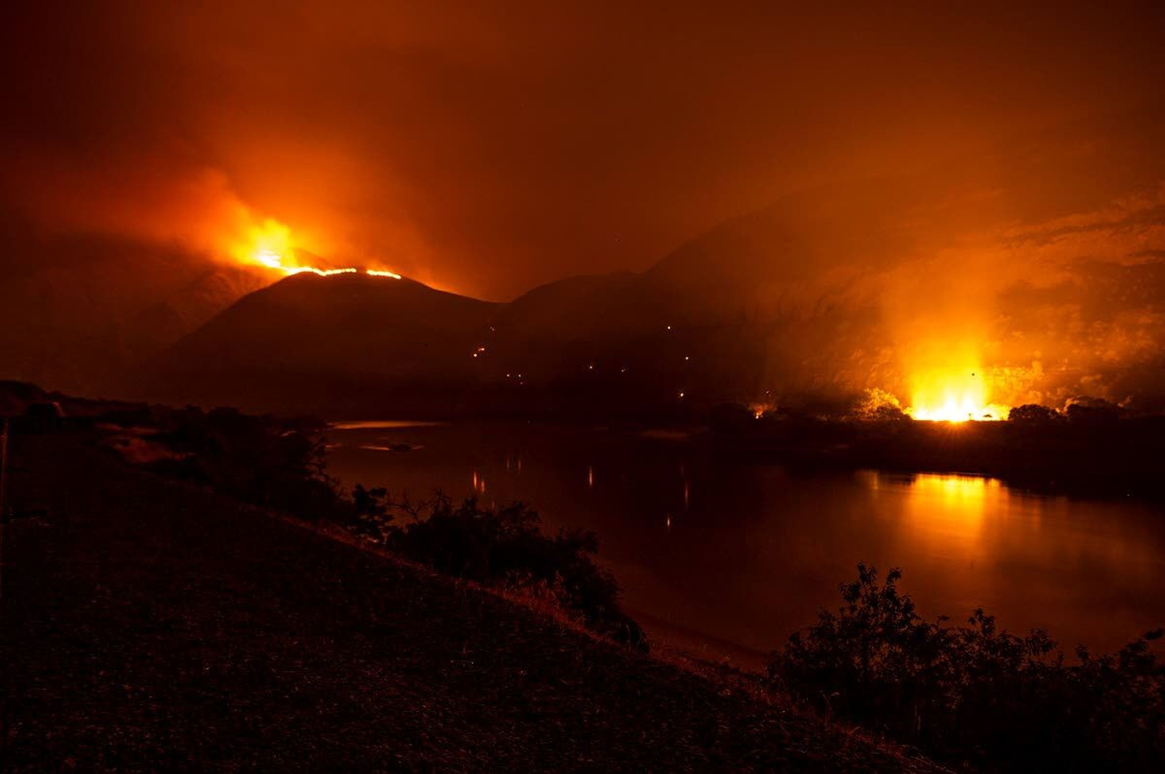 Flames from the Snake River Complex fire can be seen atop the canyon sides and even near the banks of the river on Friday night about a mile south of Buffalo Eddy.