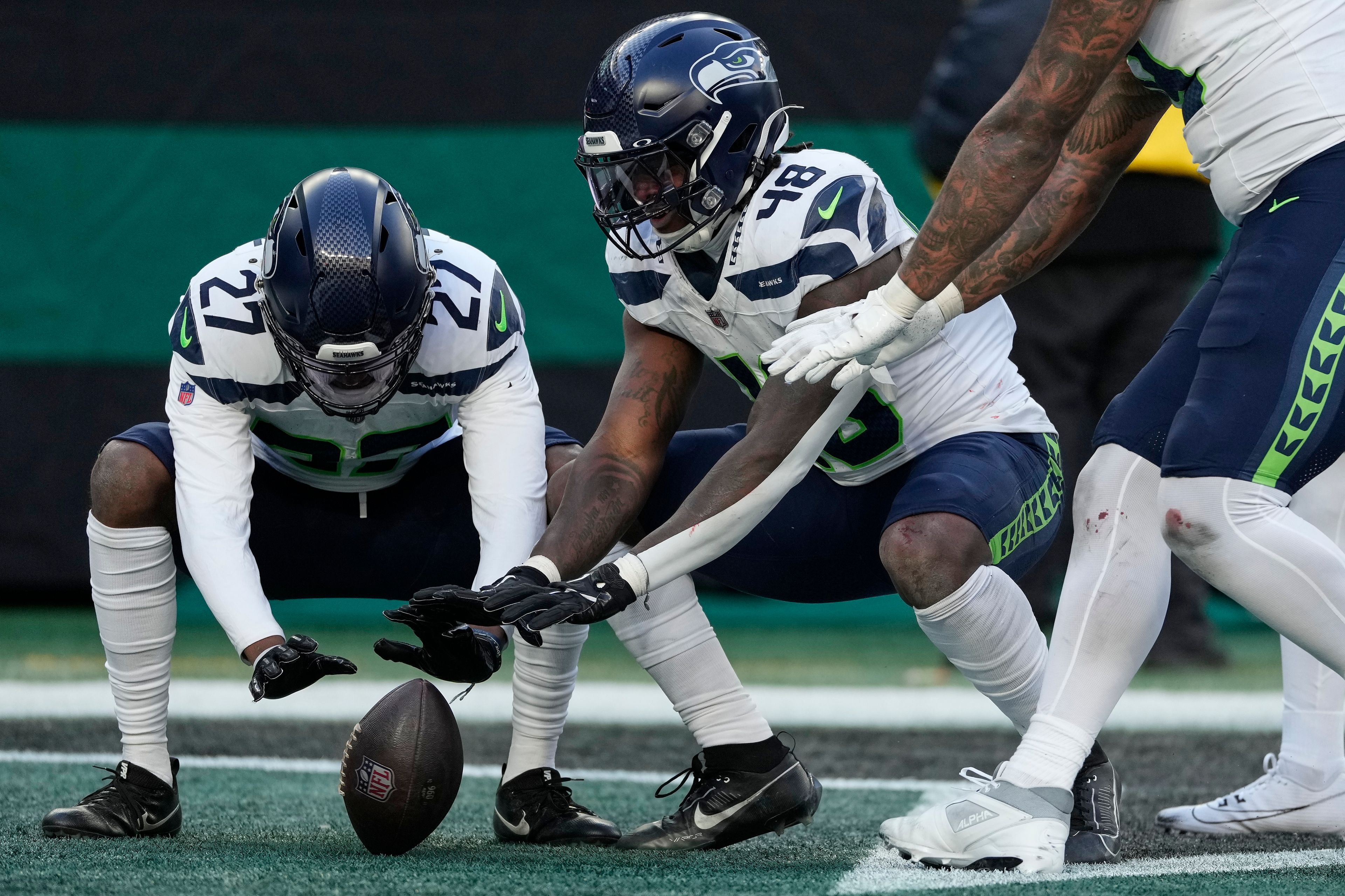 Seattle Seahawks cornerback Riq Woolen (27) and Seattle Seahawks linebacker Tyrice Knight (48) celebrate after Knight recovered a fumble by the New York Jets during the third quarter of an NFL football game, Sunday, Dec. 1, 2024, in East Rutherford, N.J. (AP Photo/Seth Wenig)