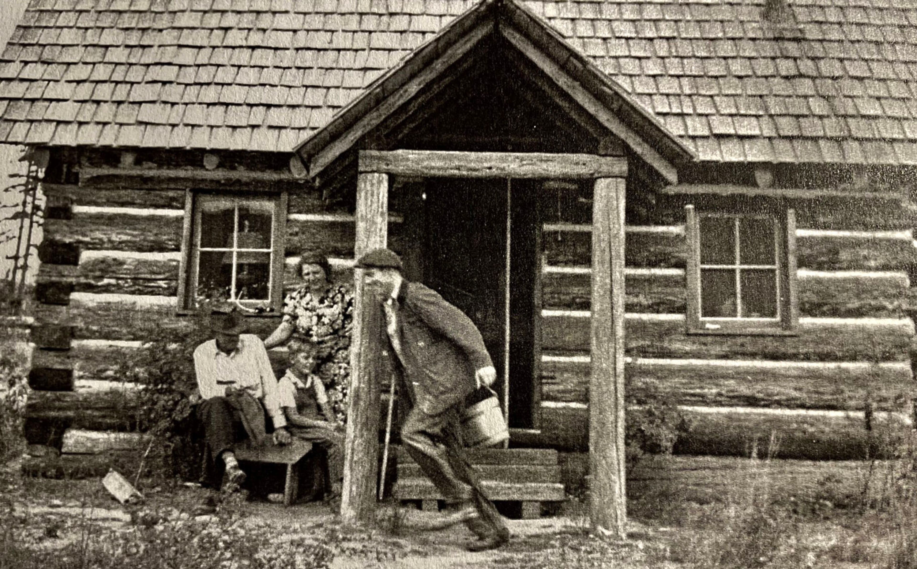 Alec Bull hams it up for his in-laws, Harry and Mary Howard, who were visiting from California by racing to the well for water. Margaret Bull's son, Stanley Stater, watches. (Margaret Bull photo)