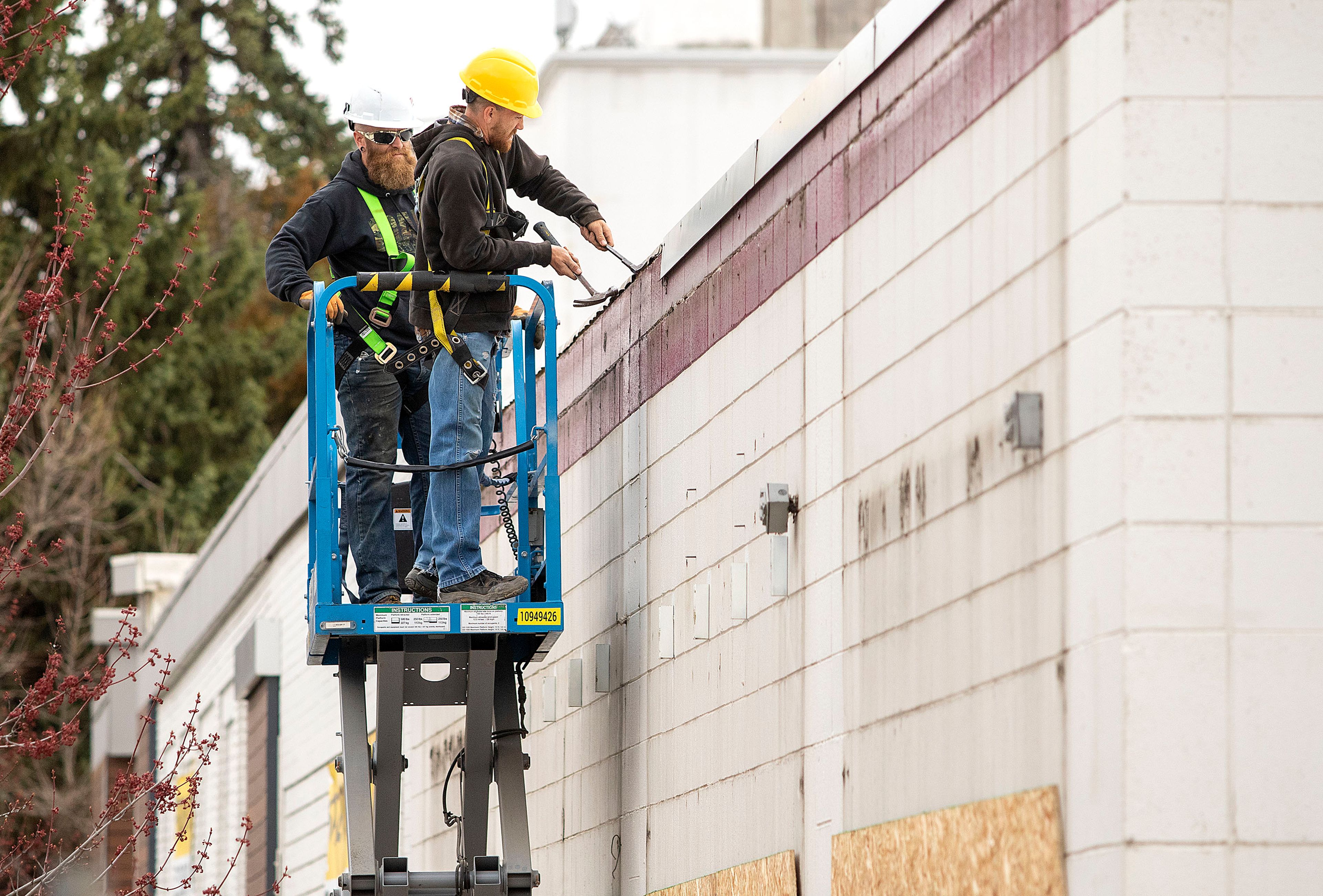 Workers remove flashing from the former Salvation Army building on Wednesday on South Jackson Street in Moscow. The building was purchased by Moscow developer Mark Wintz, and is being remodeled.