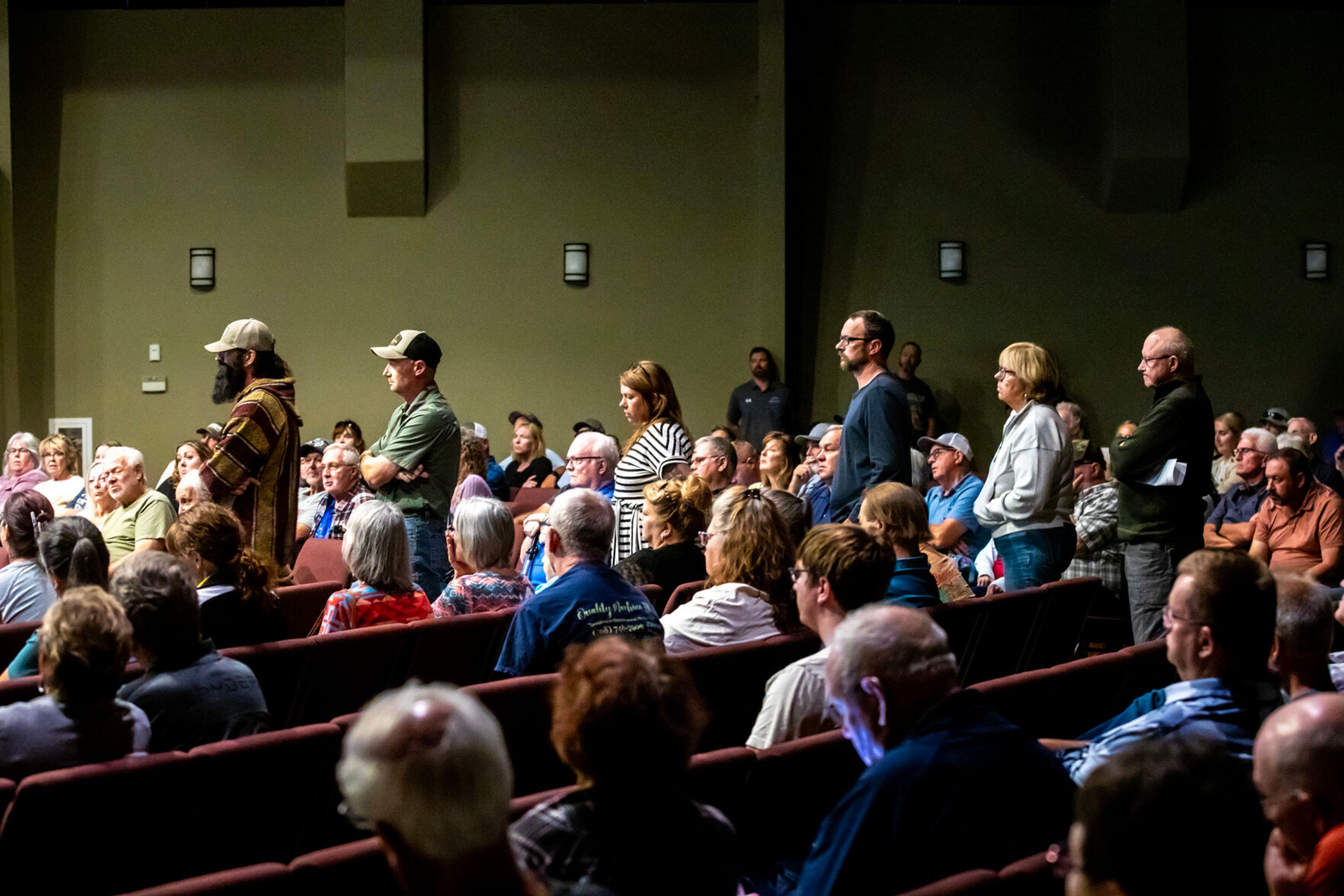 People stand in a line to ask questions at a town hall Tuesday in Clarkston.