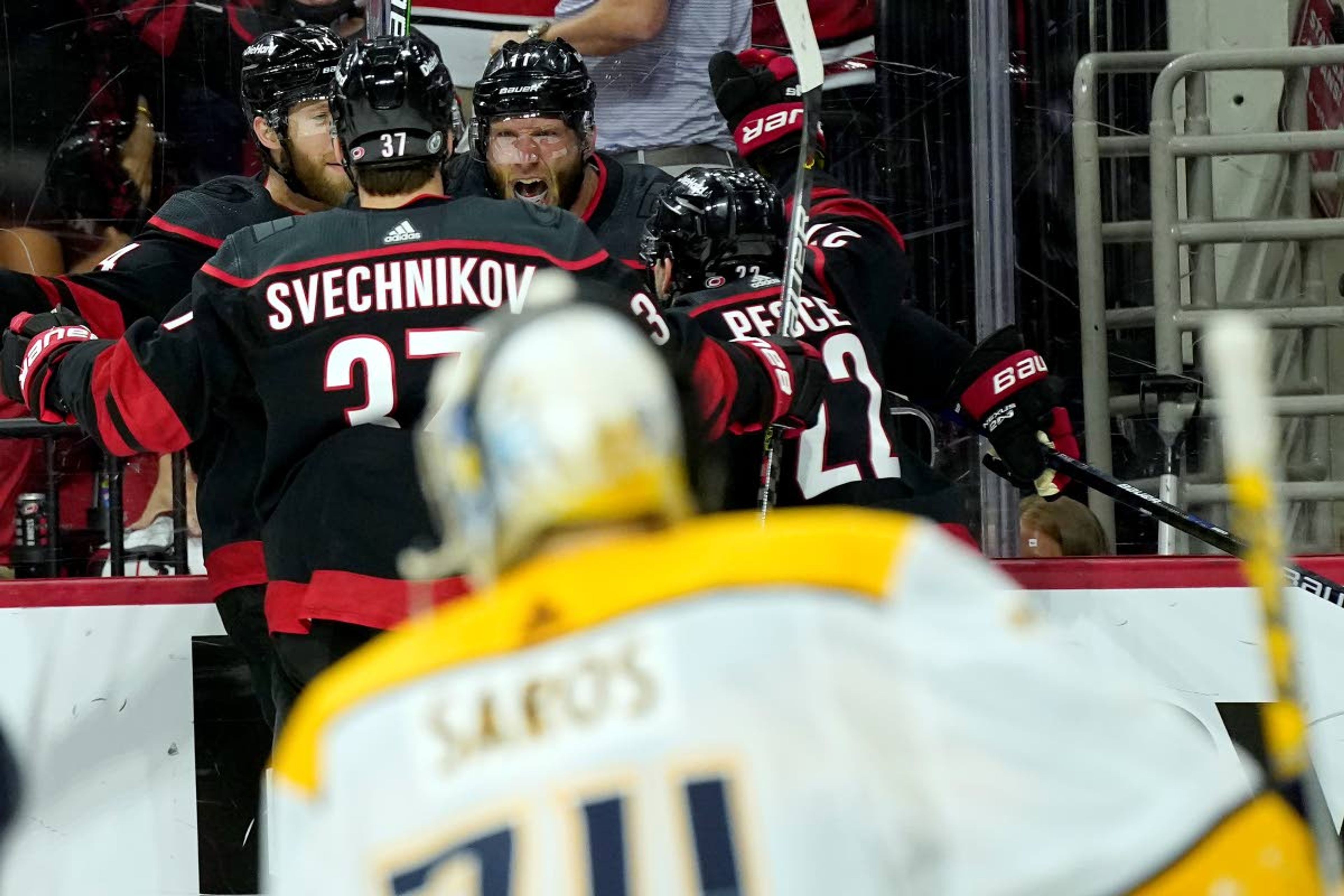 Carolina Hurricanes center Jordan Staal (11) celebrates with right wing Andrei Svechnikov (37), defenseman Jaccob Slavin (74) and defenseman Brett Pesce (22) after Staal scored in overtime against the Nashville Predators during Game 5 of an NHL hockey Stanley Cup first-round playoff series in Raleigh, N.C., Tuesday, May 25, 2021. (AP Photo/Gerry Broome)