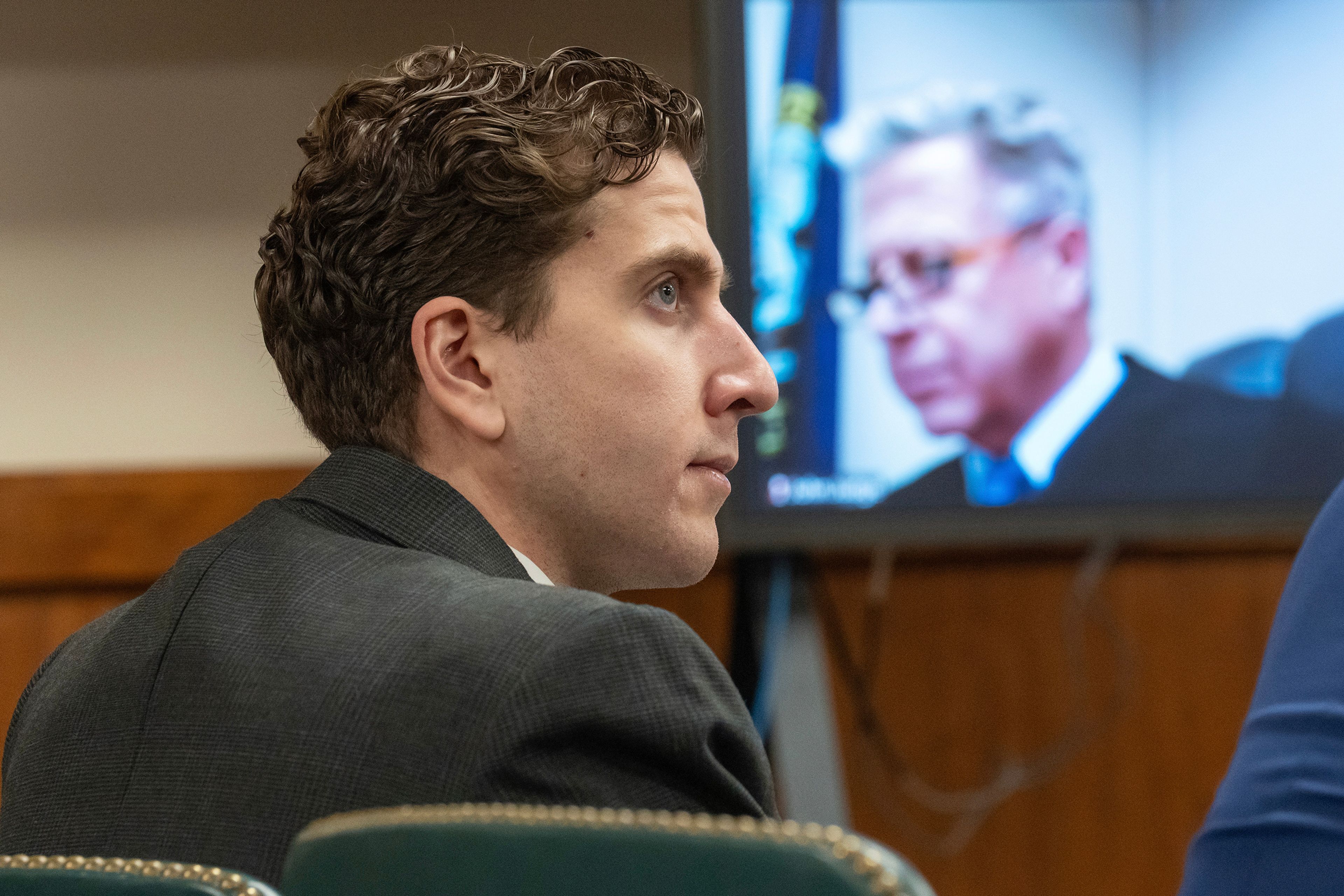 Bryan Kohberger, left, who is accused of killing four University of Idaho students in November 2022, appears at a hearing in Latah County District Court, Wednesday, Sept. 13, 2023, in Moscow, Idaho. Second District Judge John C. Judge, seen on a video display, presides over the hearing. (AP Photo/Ted S. Warren, Pool)