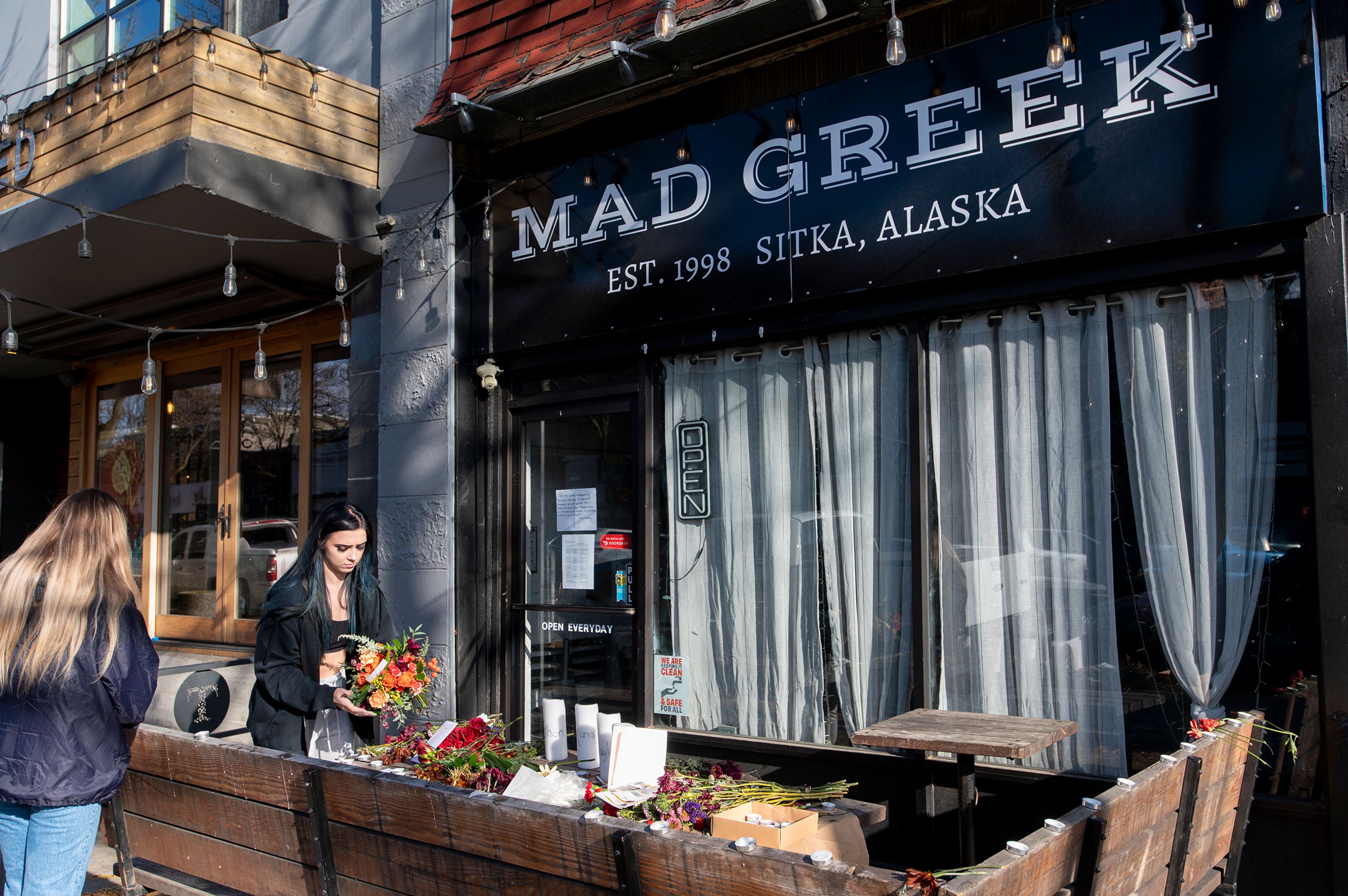 Visitors drop-off flowers in honor of four deceased University of Idaho students, including Madison Mogen and Xana Kernodle, who worked at Mad Greek in downtown Moscow, at a memorial put together by coworkers outside of the restaurant on Tuesday.