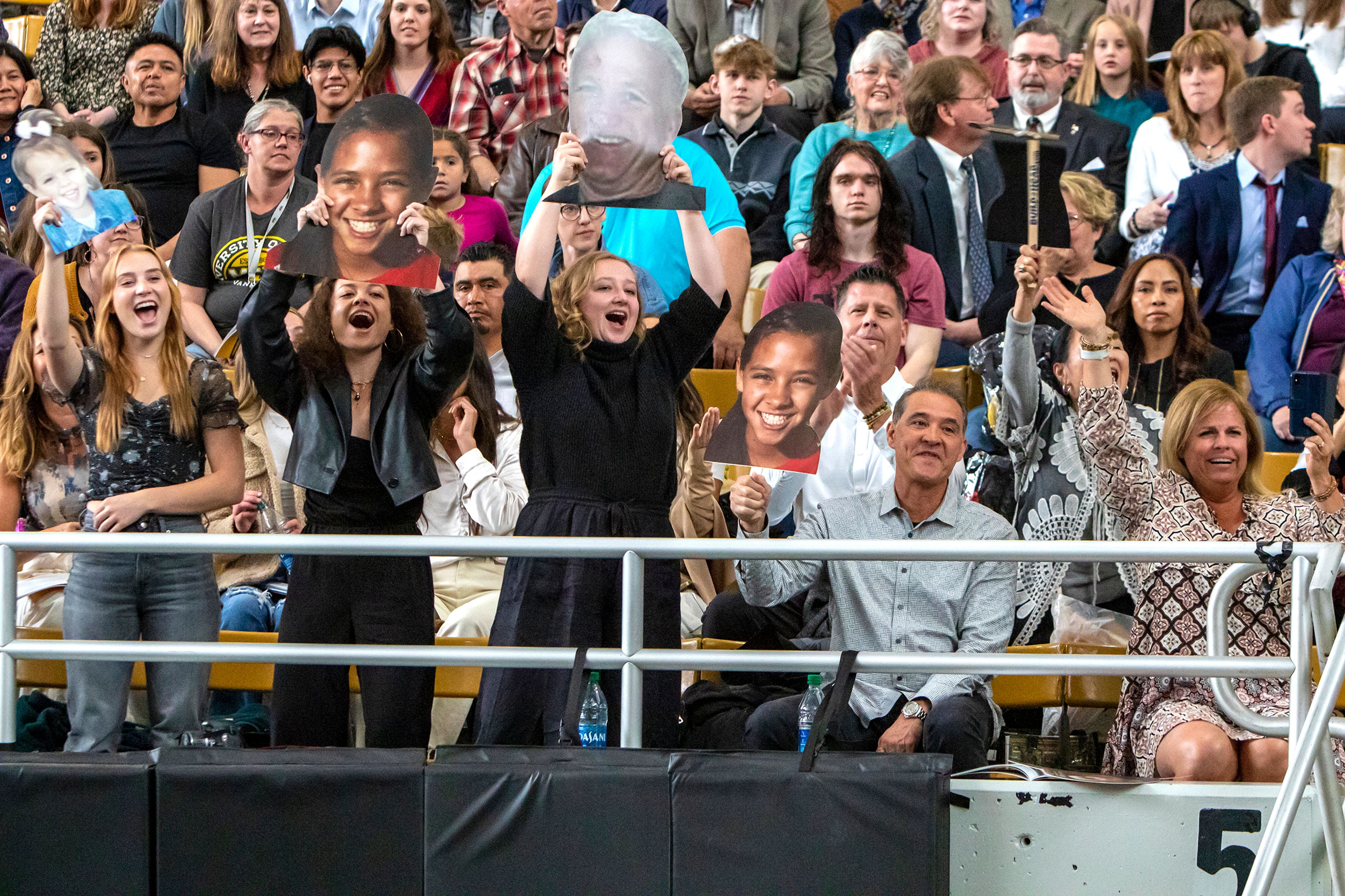 Friends and family of graduate Makenna Leigh cheer and wave cutouts as Leigh walks across the stage Saturday morning. Leigh earned a degree in exercise science and played on women’s soccer team.