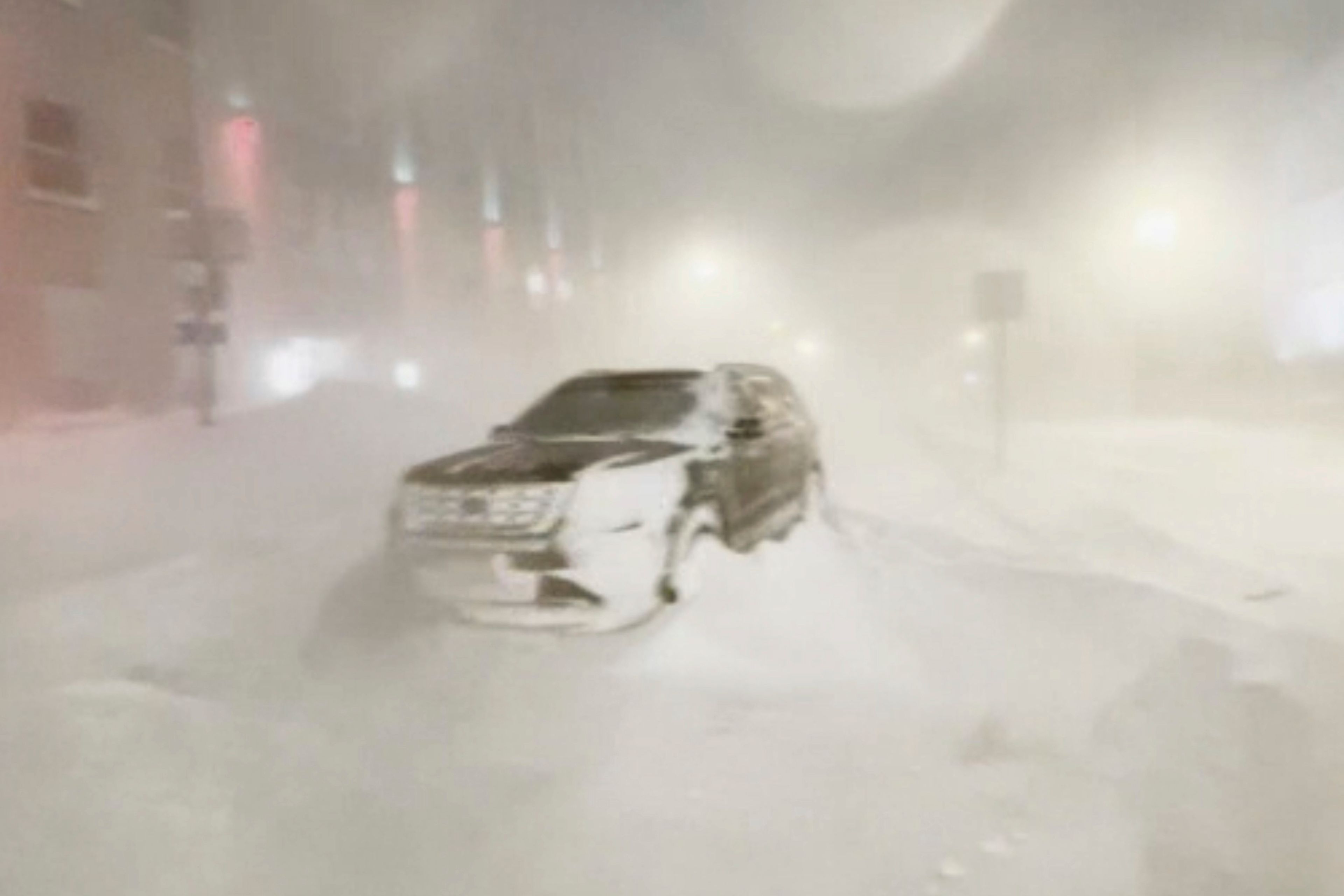 High winds and snow covers the streets and vehicles in Buffalo, N.Y. early Sunday, Dec. 25, 2022. Millions of people hunkered down in a deep freeze overnight and early morning to ride out the frigid storm that has killed at least 20 people across the United States, trapping some residents inside homes with heaping snow drifts and knocking out power to several hundred thousand homes and businesses.(WKBW via AP)