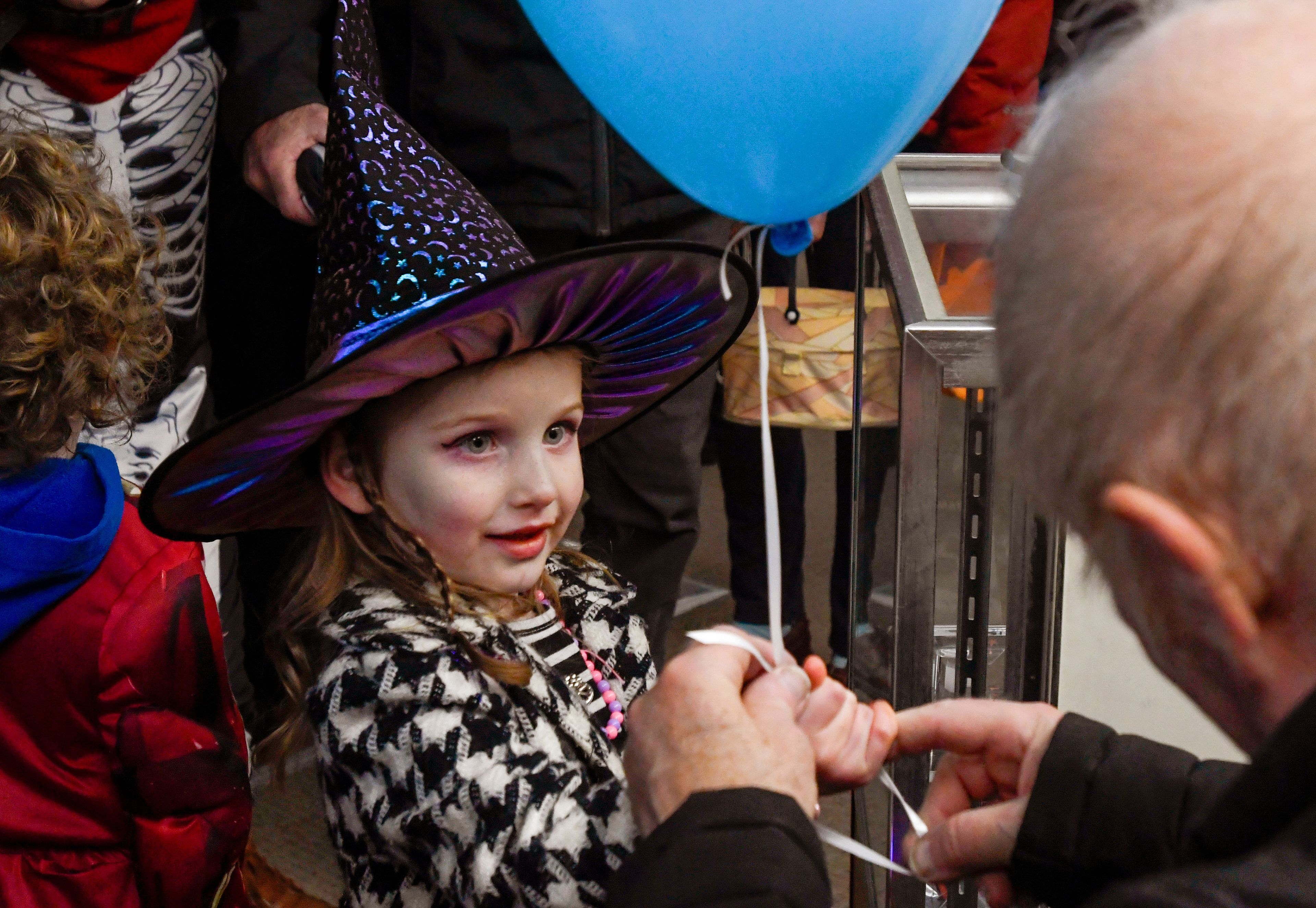 Lola Davis, 4, smiles up at Tony Ray, right, as he gives out balloons at Cactus Computer and Internet as part of Moscow’s Downtown Trick-or-Treat on Tuesday.