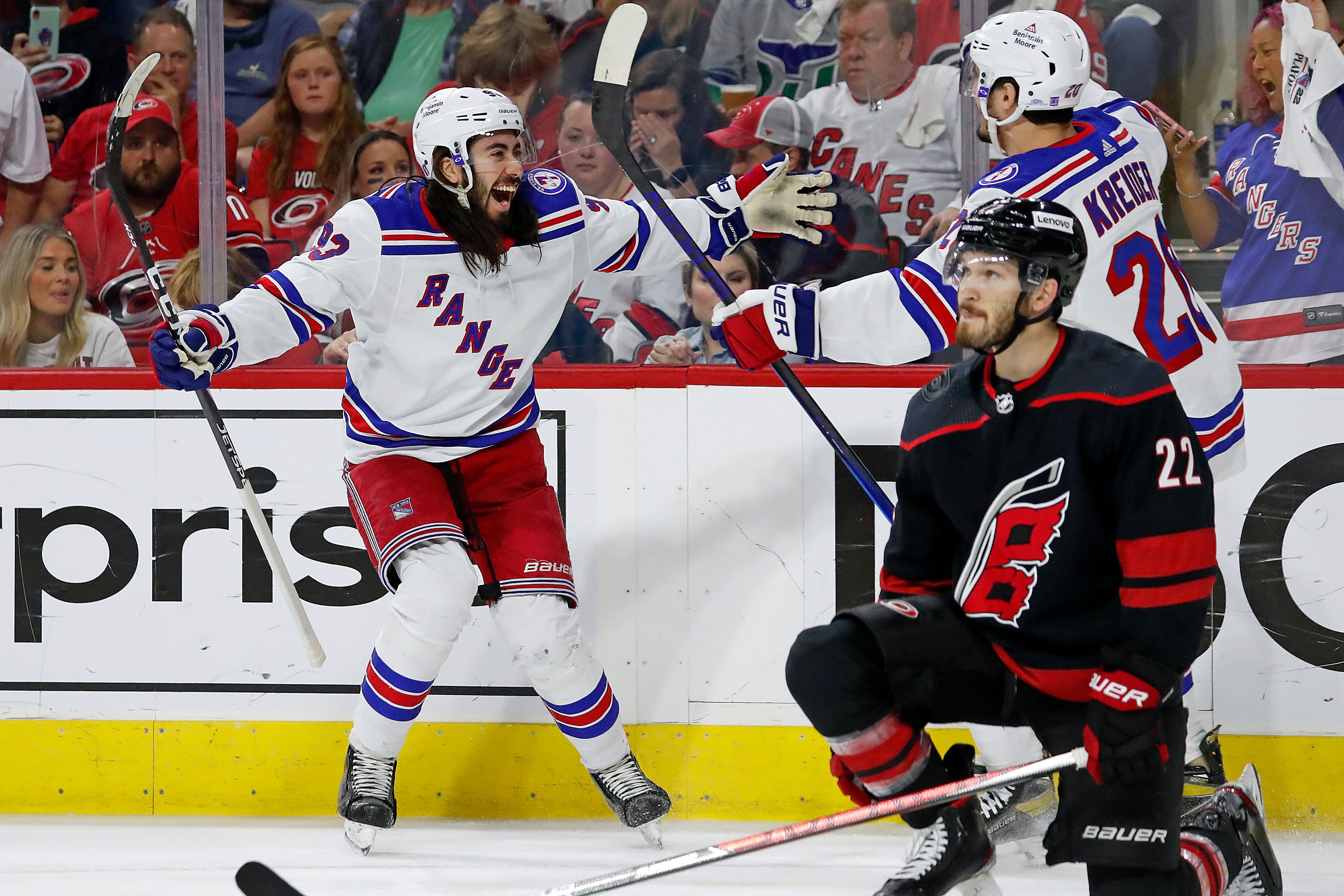 New York Rangers' Mika Zibanejad, left, congratulates Chris Kreider (20) on his goal behind Carolina Hurricanes' Brett Pesce (22) during the first period of Game 7 of an NHL hockey Stanley Cup second-round playoff series in Raleigh, N.C., Monday, May 30, 2022. (AP Photo/Karl B DeBlaker)