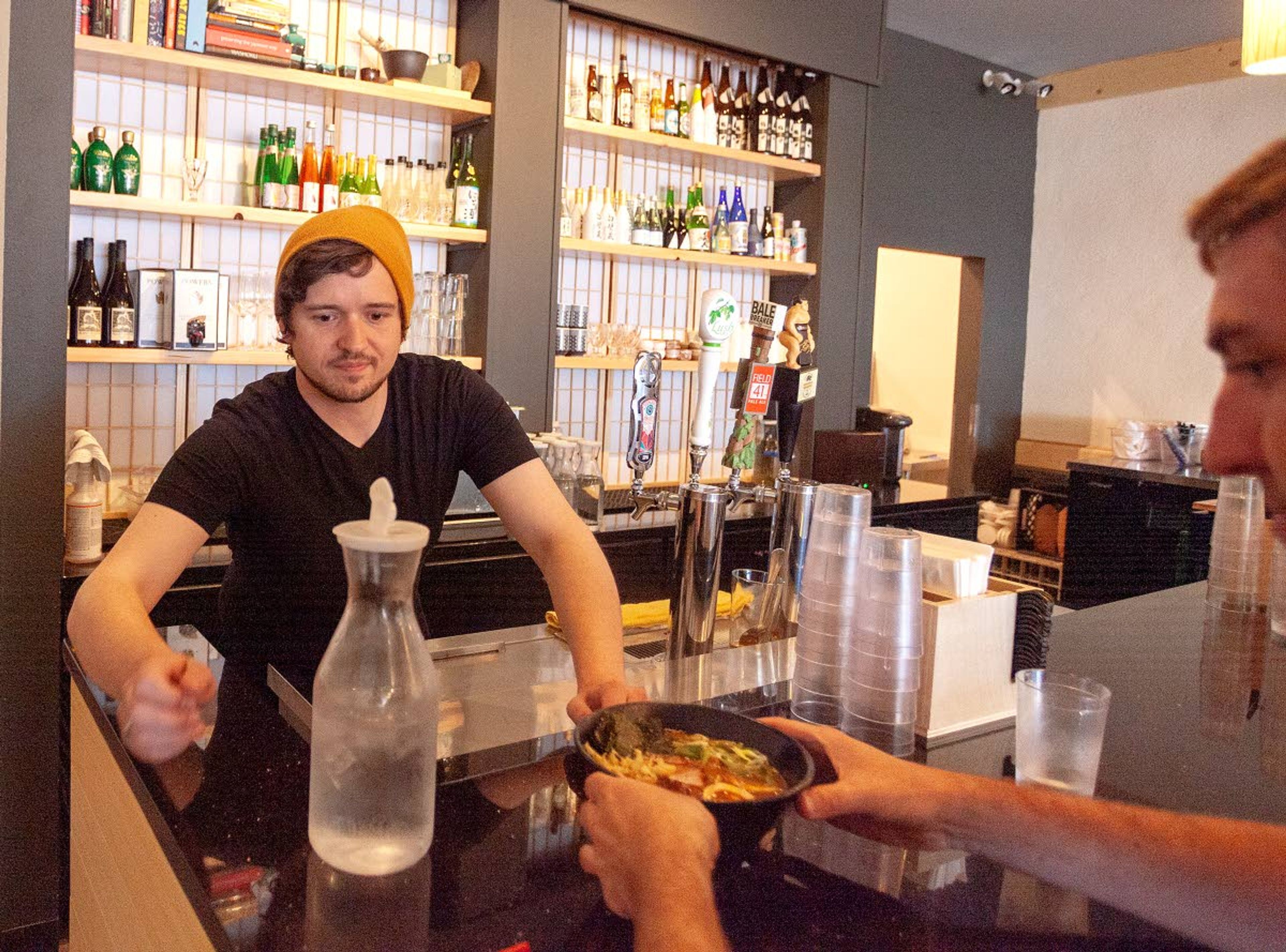 Skyler Patterson helps a customer on Thursday at O-Ramen in downtown Pullman.