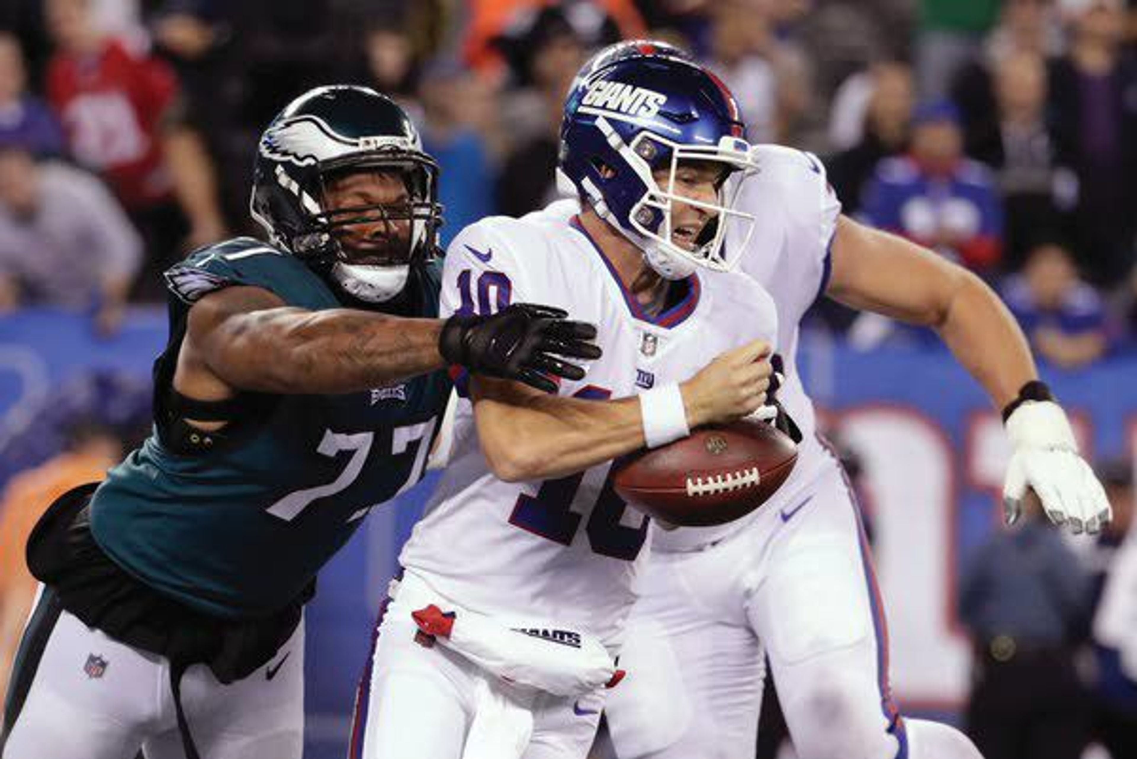 Eagles defensive end Michael Bennett (77) strips the ball from Giants quarterback Eli Manning on Thursday in East Rutherford, N.J.