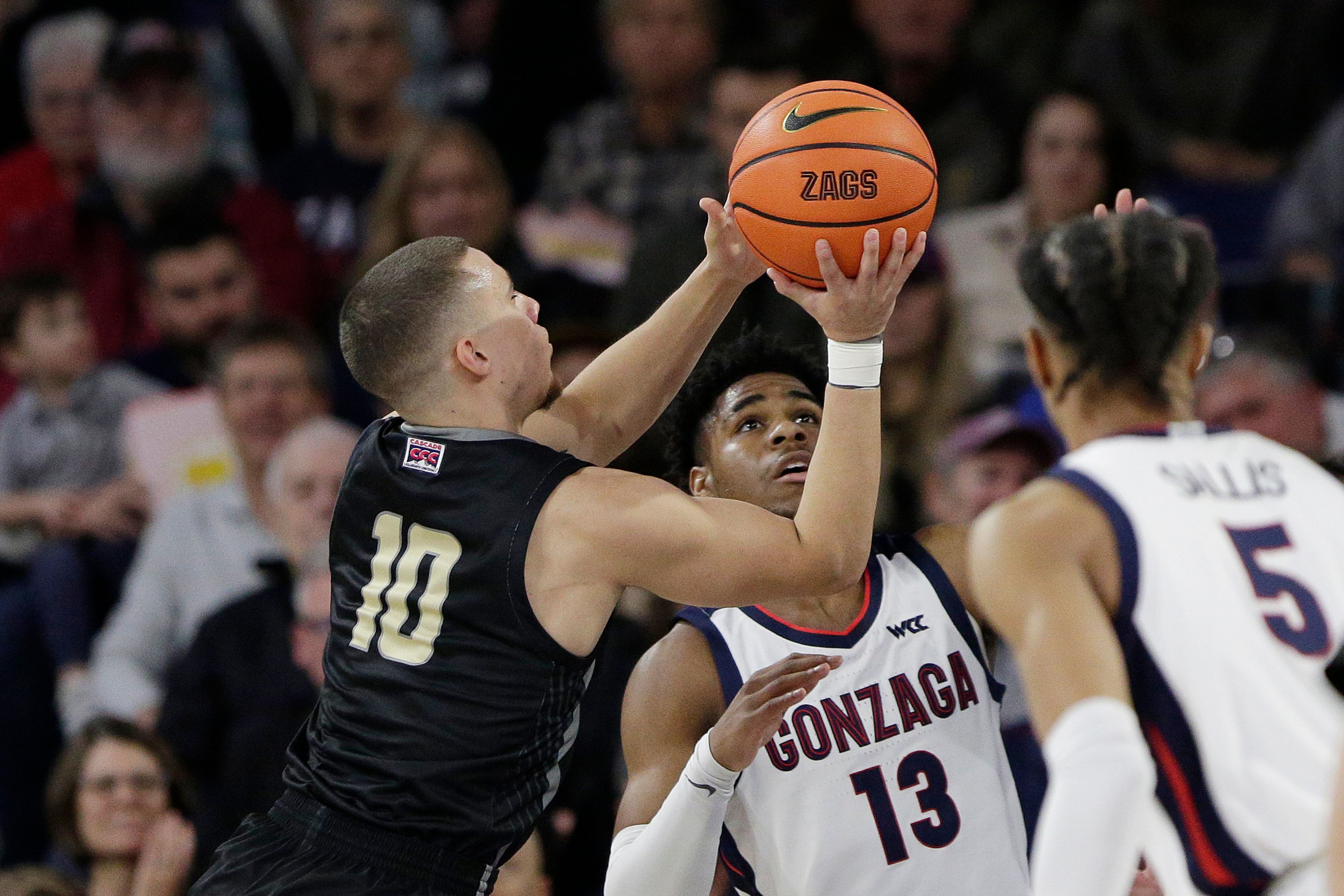 Eastern Oregon guard Malachi Afework (10) shoots while defended by Gonzaga guard Malachi Smith (13) during the first half of a college basketball game, Wednesday, Dec. 28, 2022, in Spokane, Wash. (AP Photo/Young Kwak)