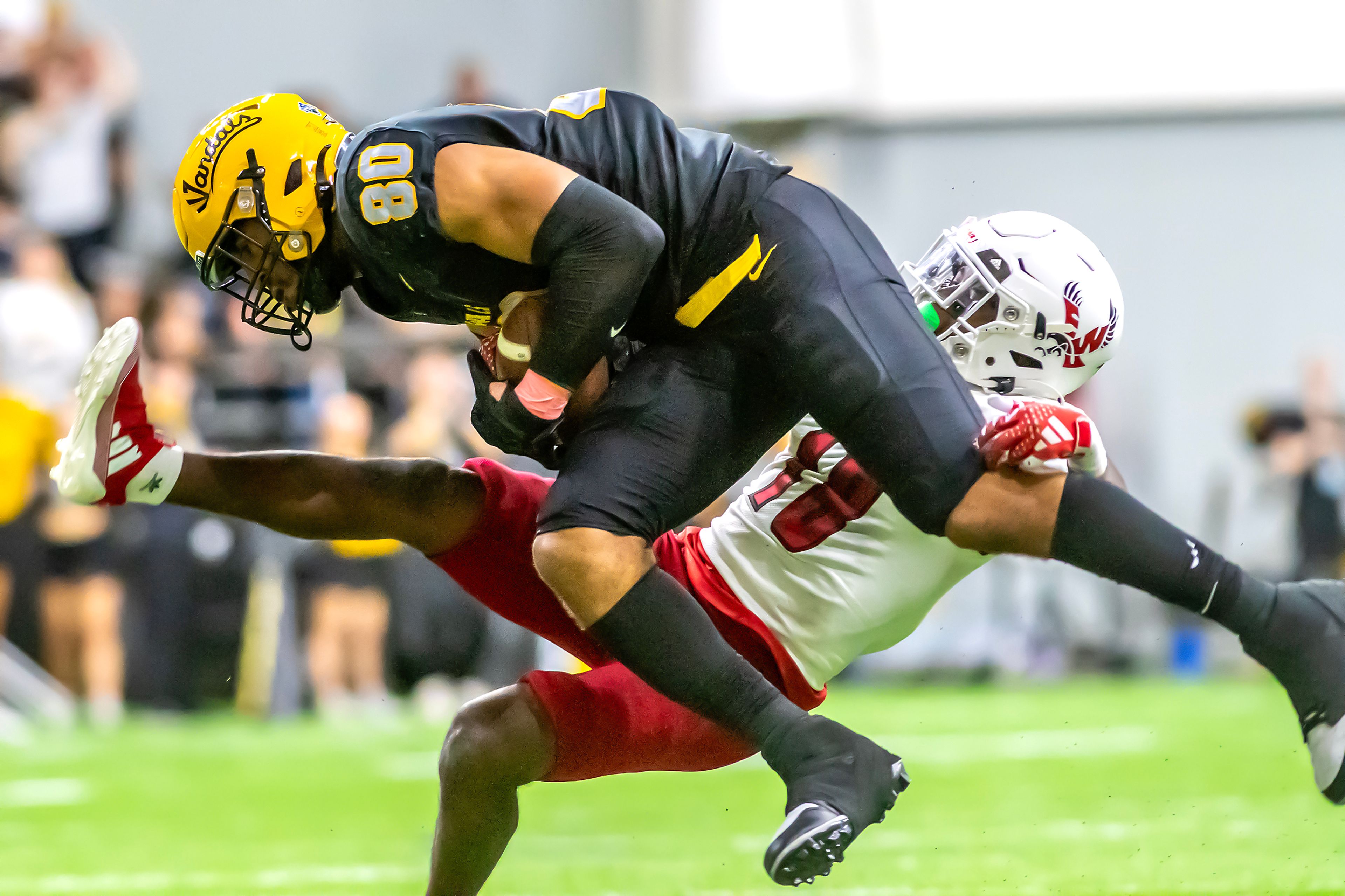 Idaho tight end Mike Martinez comes down with Eastern Washington safety Derek Ganter Jr. after making a catch during a Big Sky game Saturday at the Kibbie Dome in Moscow. ,