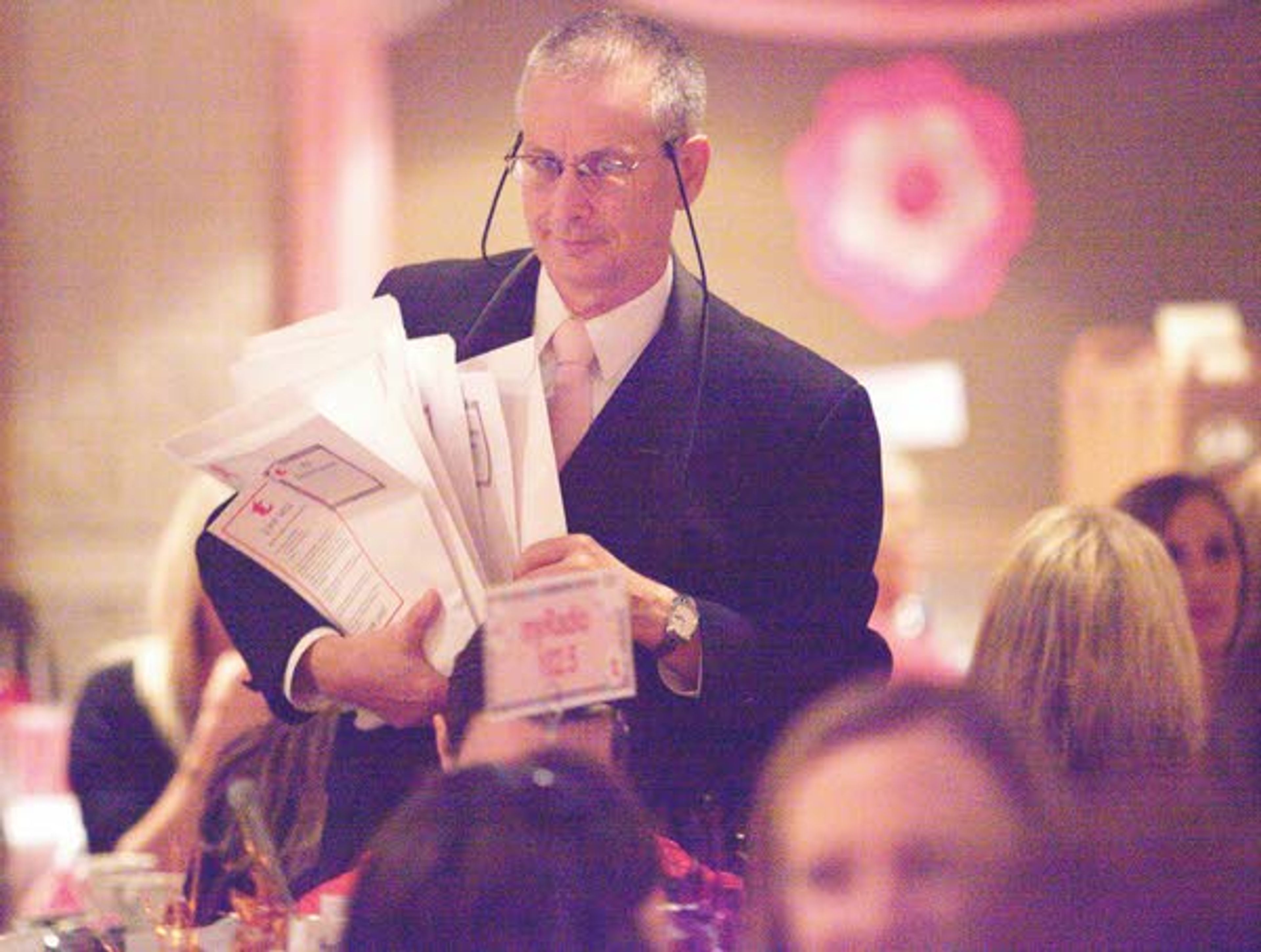 Paul Weston collection donation envelopes during the 12th Annual Pink Tea sponsored by Gritman Medical Center on Tuesday at the Best Western Plus University Inn in Moscow. The Pink Tea raises money for the Bosom Buddies program that provides free mammograms at Gritman to those who cannot afford one.