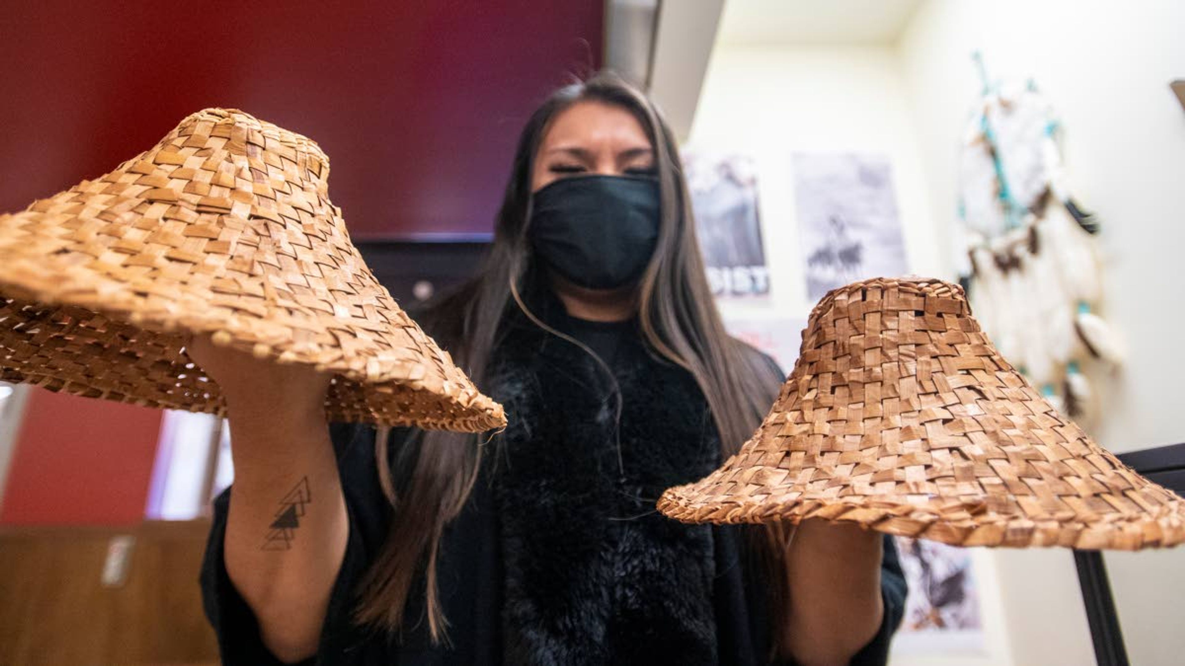 Mondejar holds two cedar hats made with Mondejar's mother. Mondejar said the hats vary in size. The smaller has was created when Mondejar was younger.