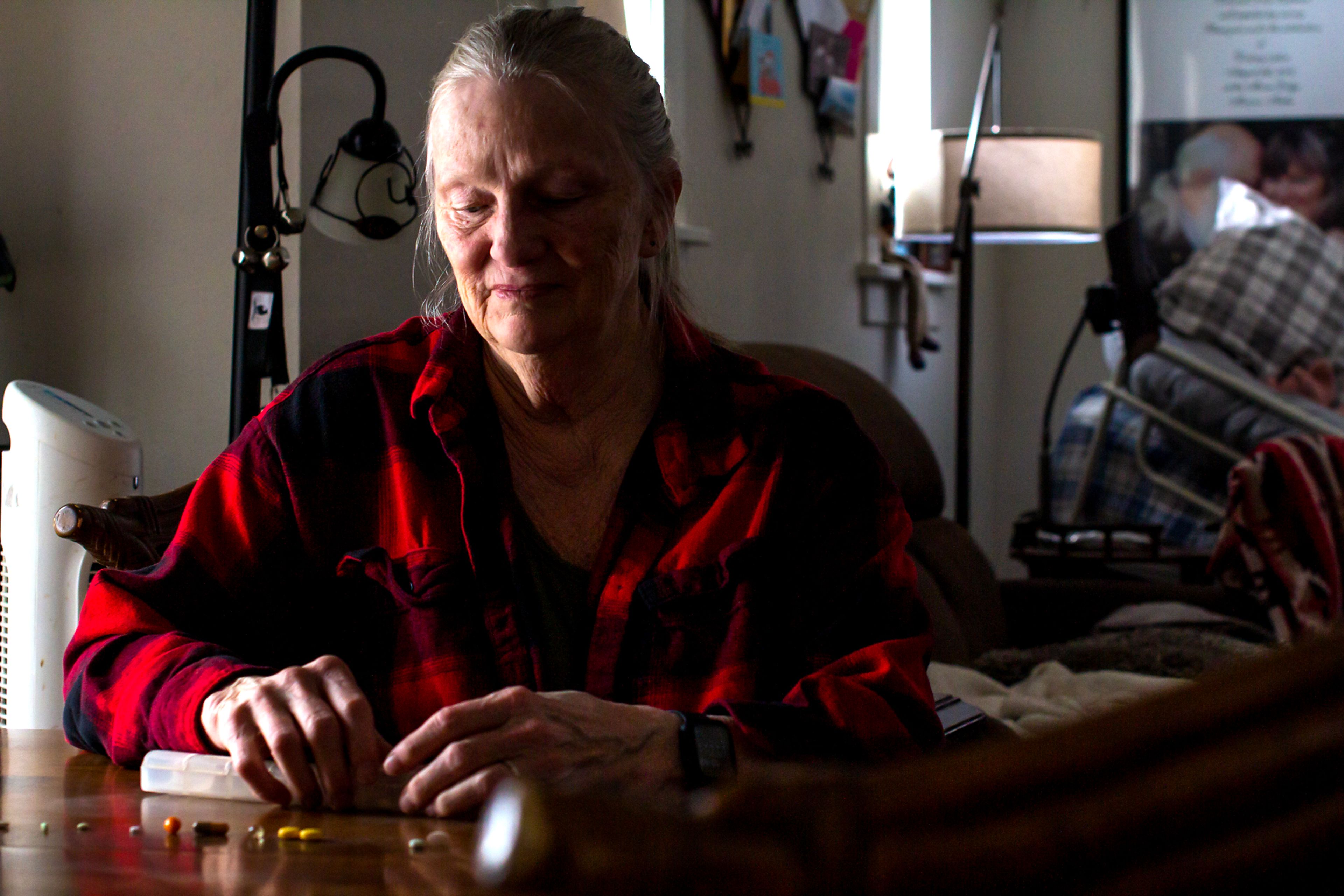 Deborah Becket lines up all of her husband Geoff Beckett’s medications and supplements. She is currently paying for his medications out of pocket to continue filling prescriptions at their local pharmacy after Kaiser Permanente switched customers’ maintenance medications to mail order this year.