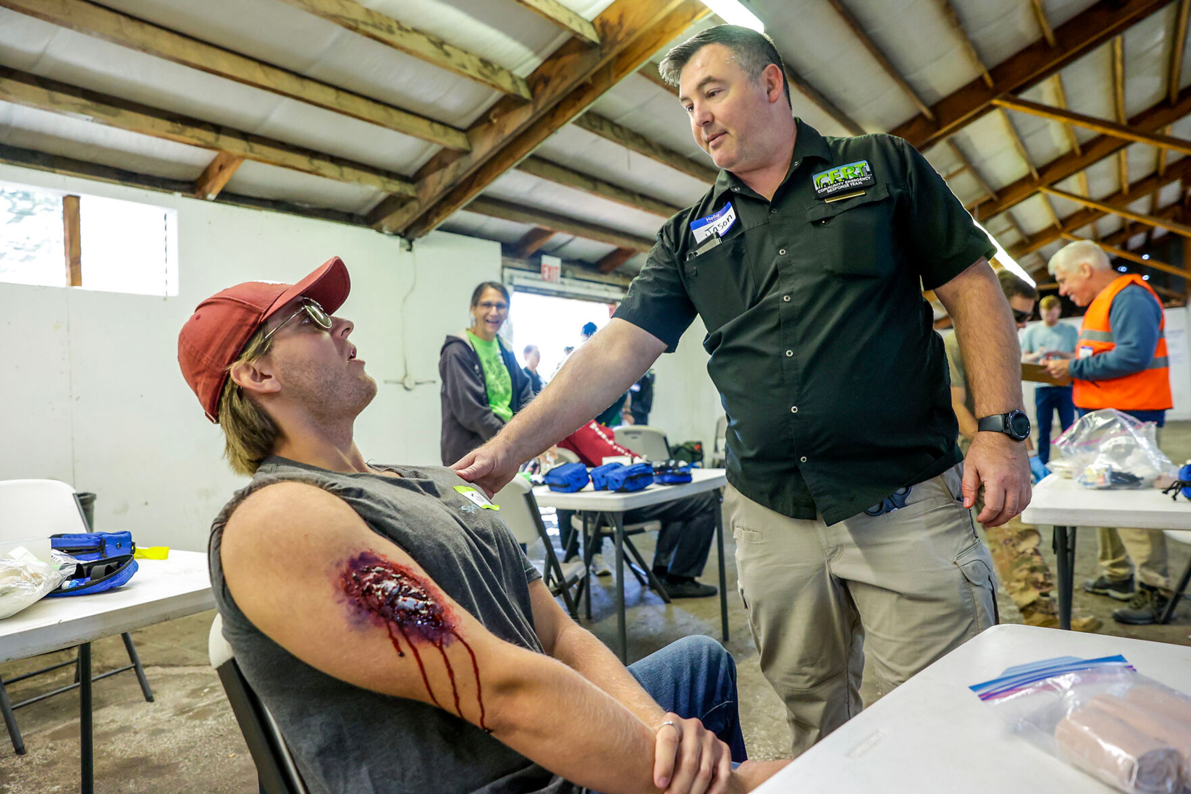 Jason Stooks talks to Jax Monti, of Pullman, as he deals with an arm injury during a disaster simulation of a windstorm Saturday at the Latah County Fairgrounds.