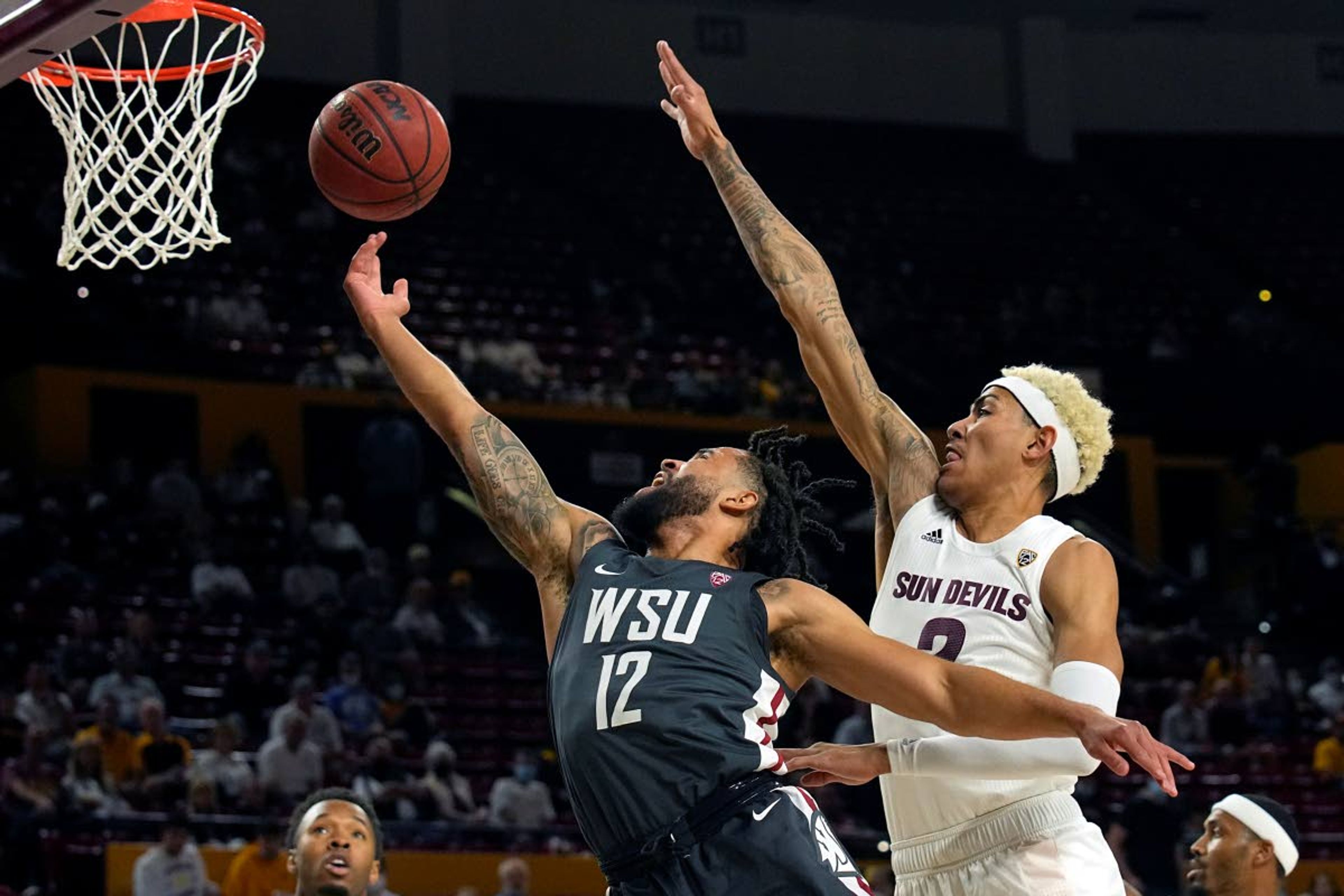 Washington State guard Michael Flowers (12) drives past Arizona State forward Jalen Graham during the first half of an NCAA college basketball game Wednesday, Dec. 1, 2021, in Tempe, Ariz. (AP Photo/Rick Scuteri)