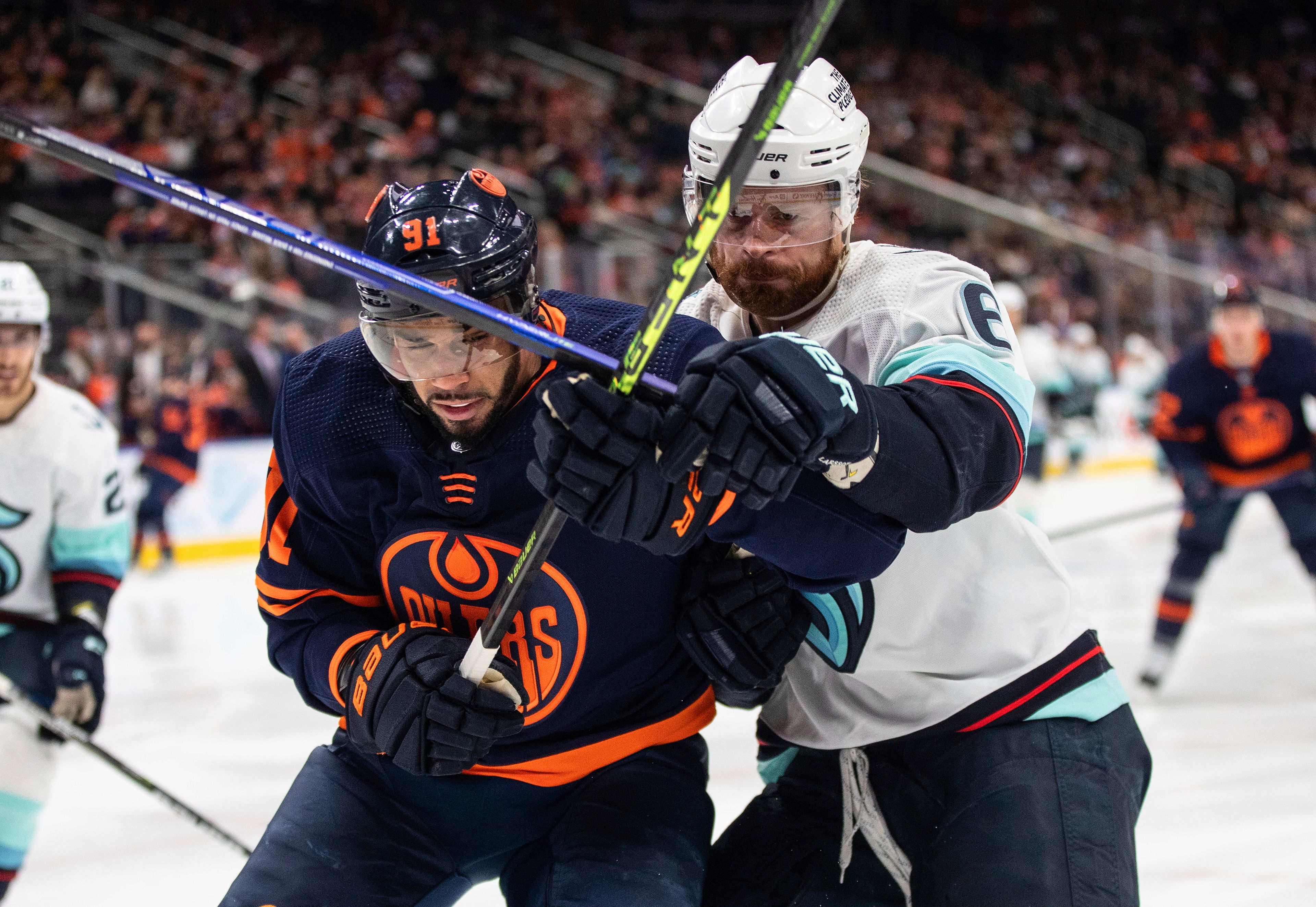 Seattle Kraken's Adam Larsson (6) and Edmonton Oilers' Evander Kane (91) compete for the puck during the second period of an NHL hockey game Tuesday, Jan. 17, 2023, in Edmonton, Alberta. (Jason Franson/The Canadian Press via AP)