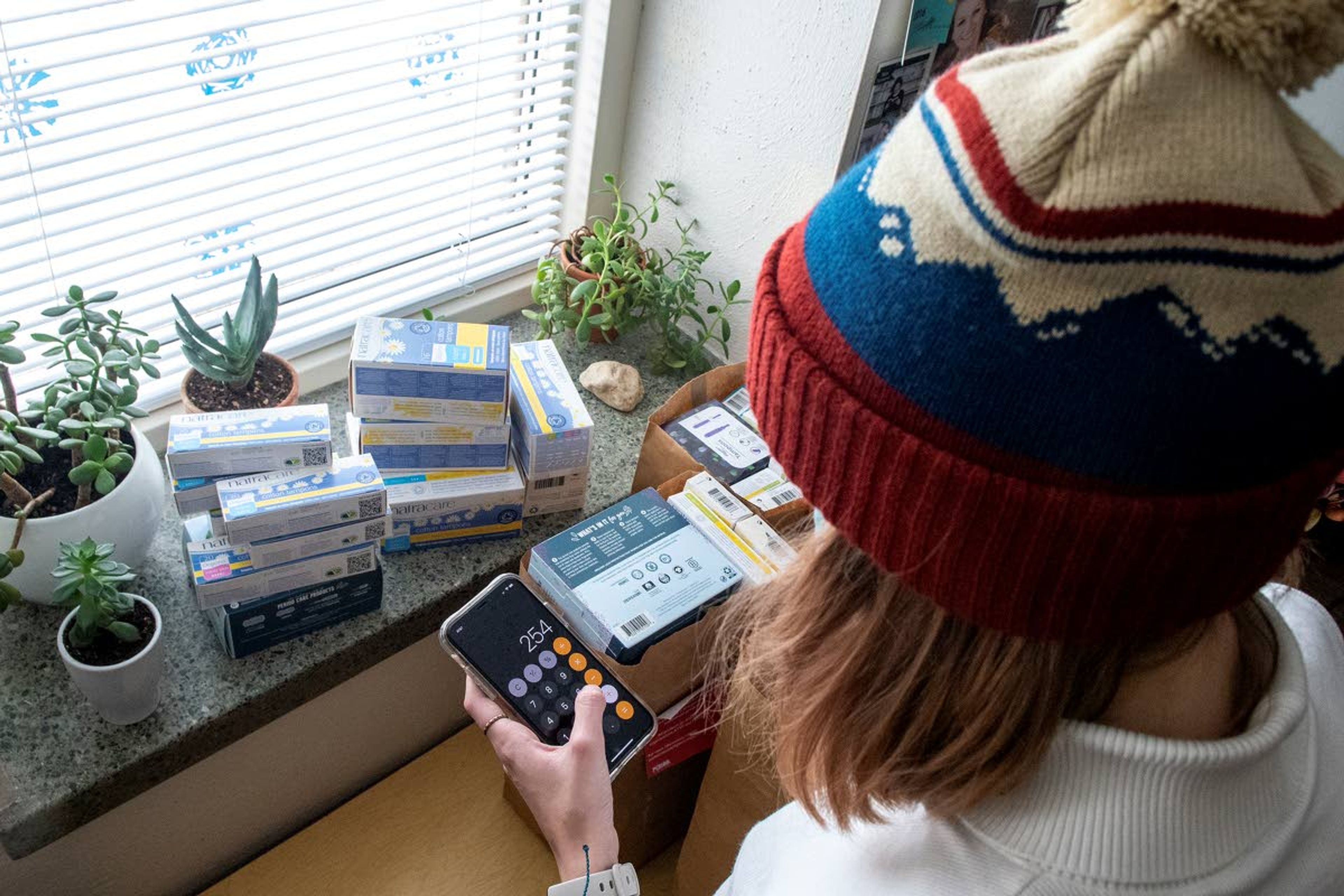 Madeline Schab, a junior at Moscow High School, and member of “PERIOD: The Menstrual Movement,” uses a calculator app to count various period product supplies.