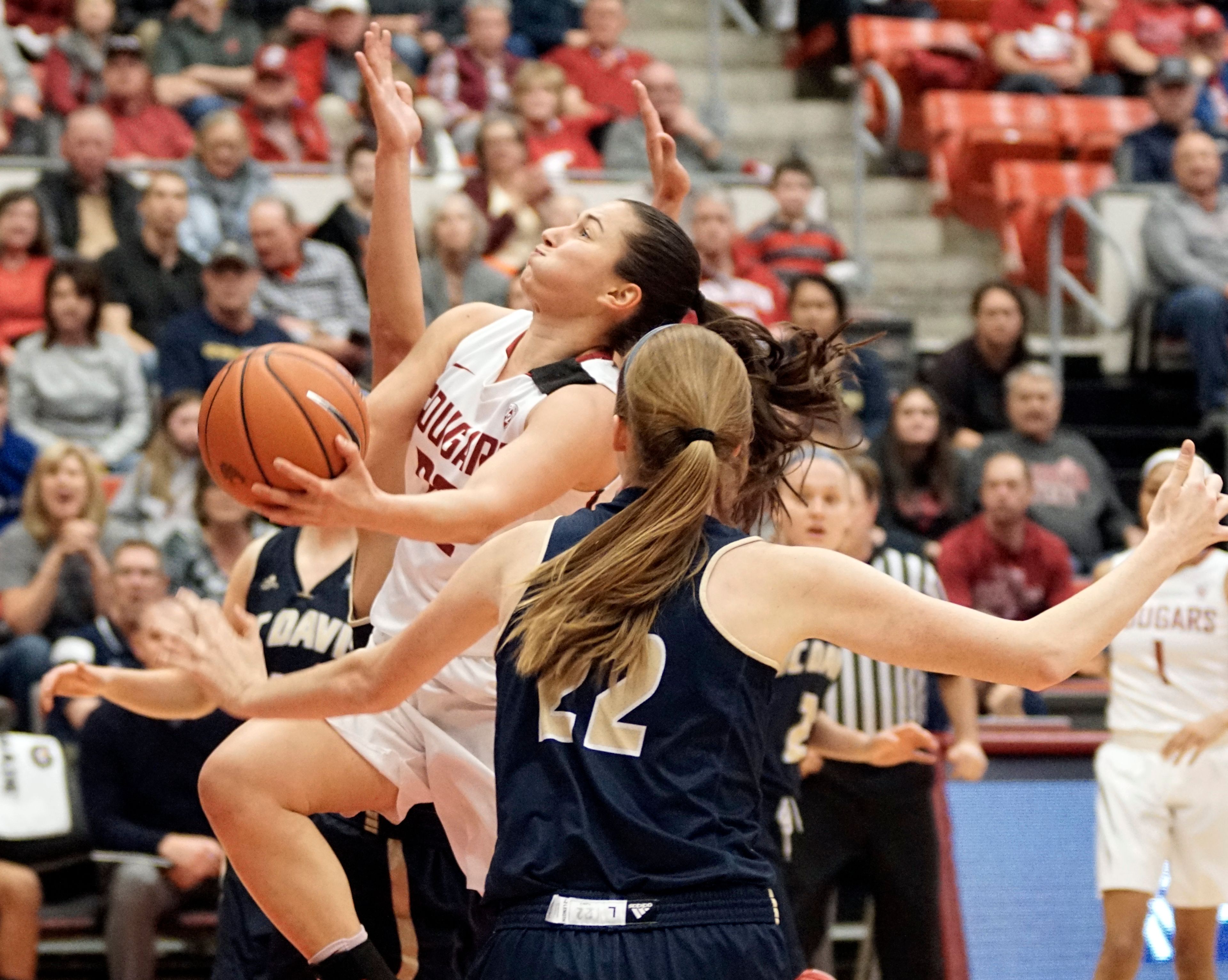 Washington State guard Pinelopi Povlopoulou drives between a pair of UC Davis defenders for a layup in the first quarter of a third round game in the Women's National Invitation Tournament at Beasely Coliseum Thursday night.