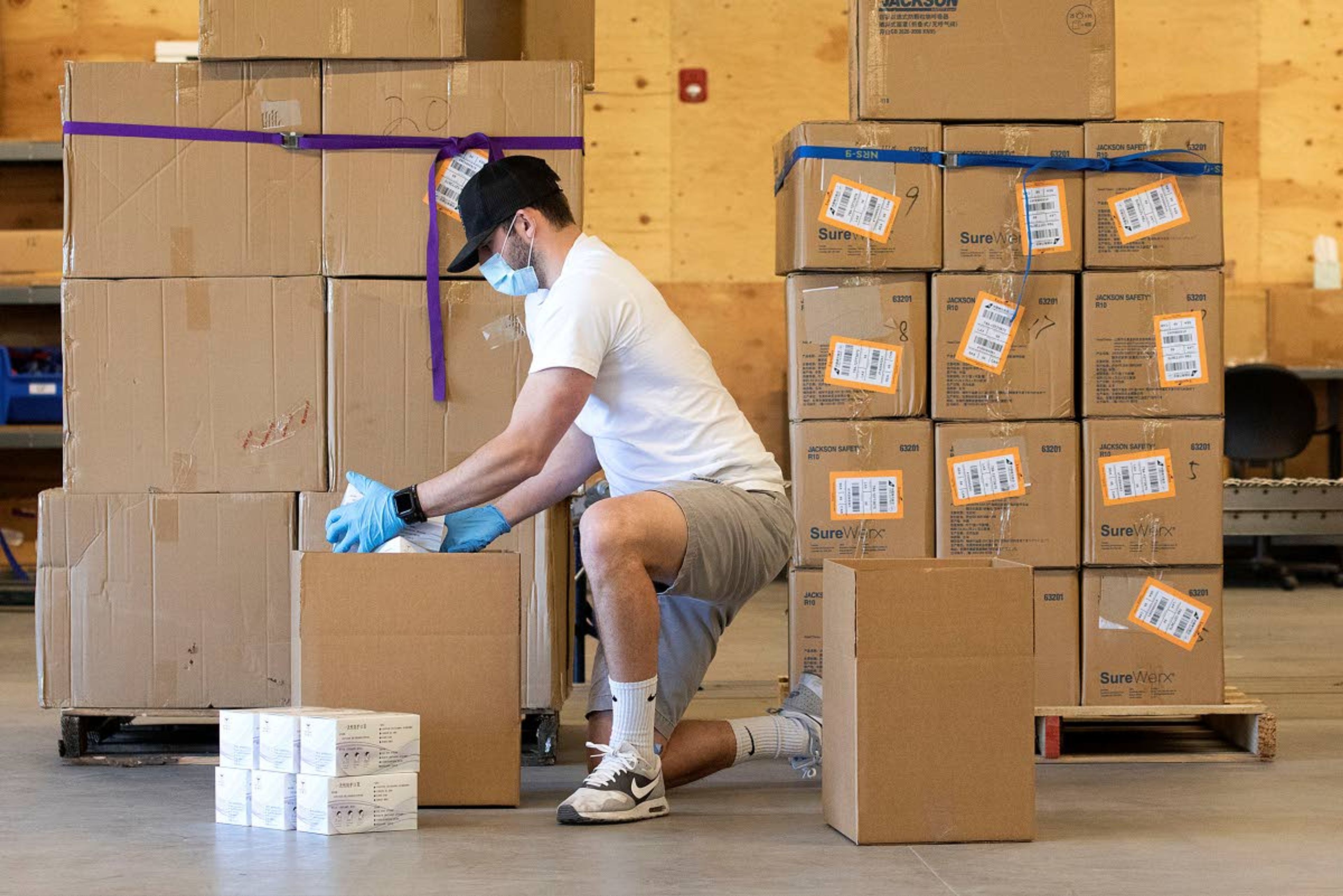 Garrett Payne packs boxes with disposable protective masks after receiving a shipment of masks, KN95 respirators and latex gloves on Thursday at Northwest River Supplies in Moscow. NRS donated 500 masks each to the Moscow Volunteer Fire Department and the Pullman Fire Department. The remainder of the shipment has been purchased by area hospitals and first responders.