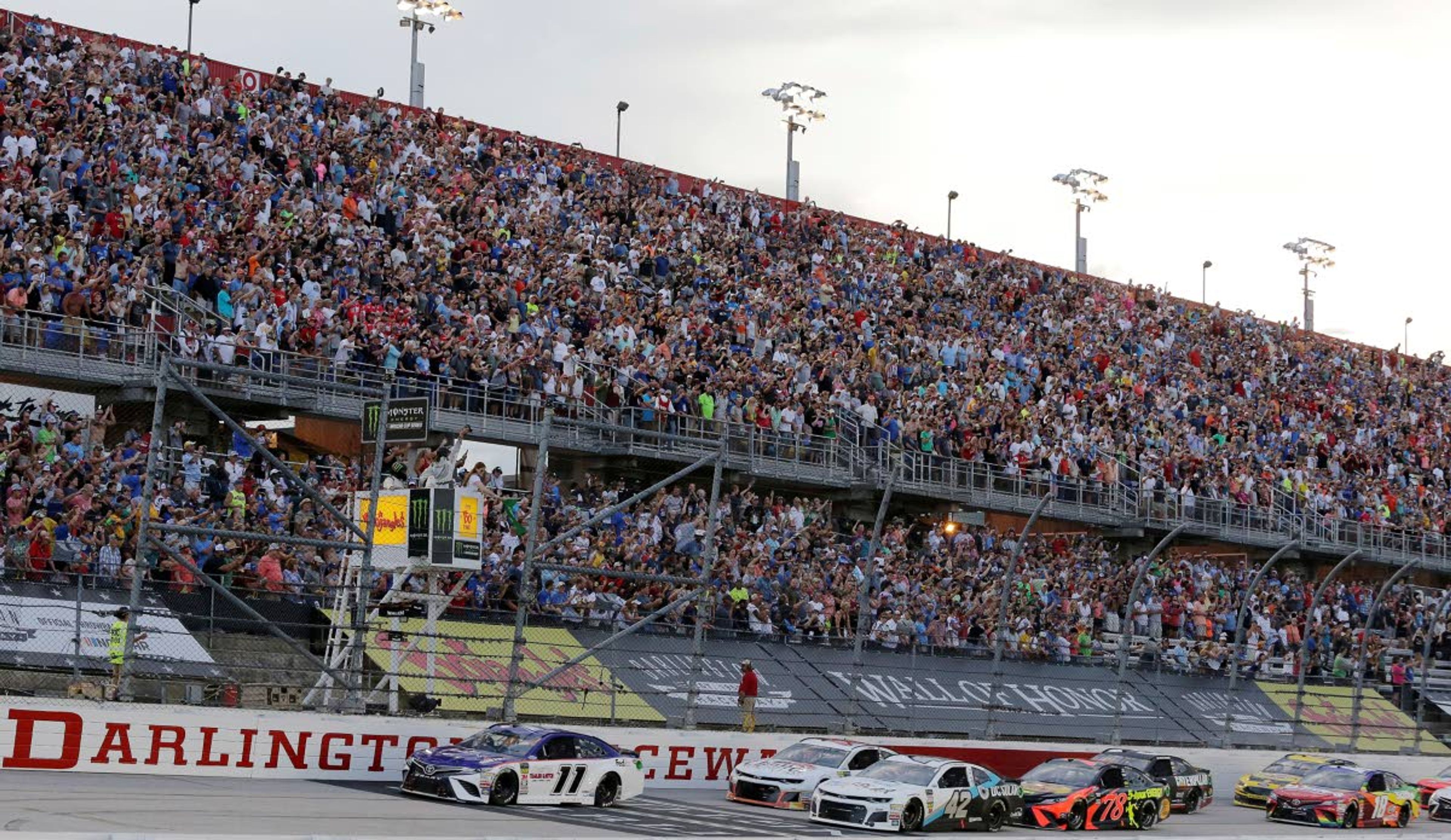 FLE - In this Sept. 2, 2018, file photo, Denny Hamlin (11) leads the pack to start the NASCAR Cup Series auto race at Darlington Raceway in Darlington, S.C. NASCAR will get its season back on track starting May 17 at Darlington Raceway in South Carolina without spectators, and the premier Cup Series plans to race four times in 10 days at a pair of iconic tracks. The revised schedule released Thursday, April 30, 2020, goes only through May and has a pair of Wednesday races — fulfilling fans longtime plea for midweek events. (AP Photo/Terry Renna, File)