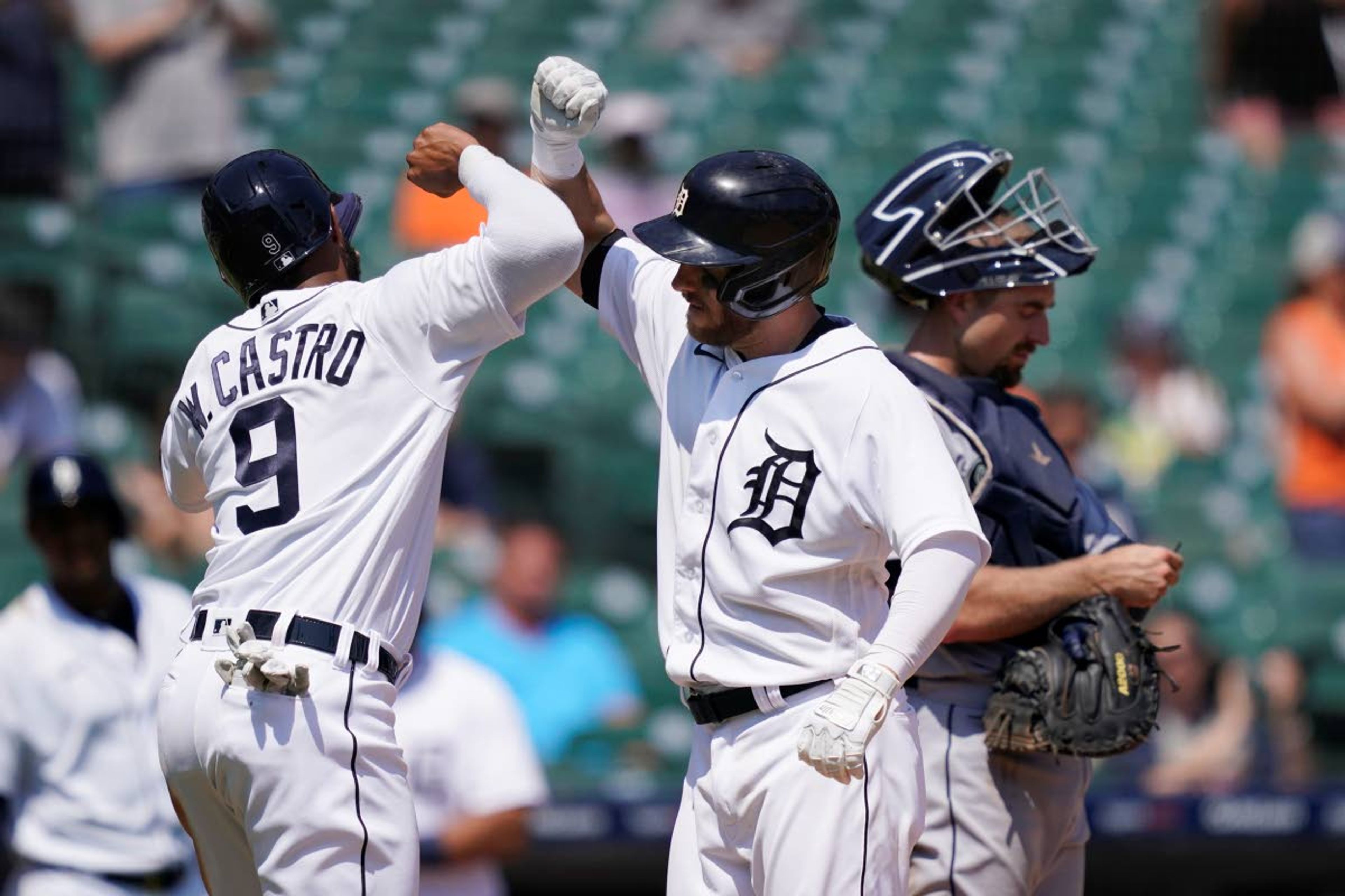 Detroit Tigers' Willi Castro greets Robbie Grossman next to Seattle Mariners catcher Tom Murphy after they scored on Grossman's two-run home run during the sixth inning of a baseball game, Thursday, June 10, 2021, in Detroit. (AP Photo/Carlos Osorio)