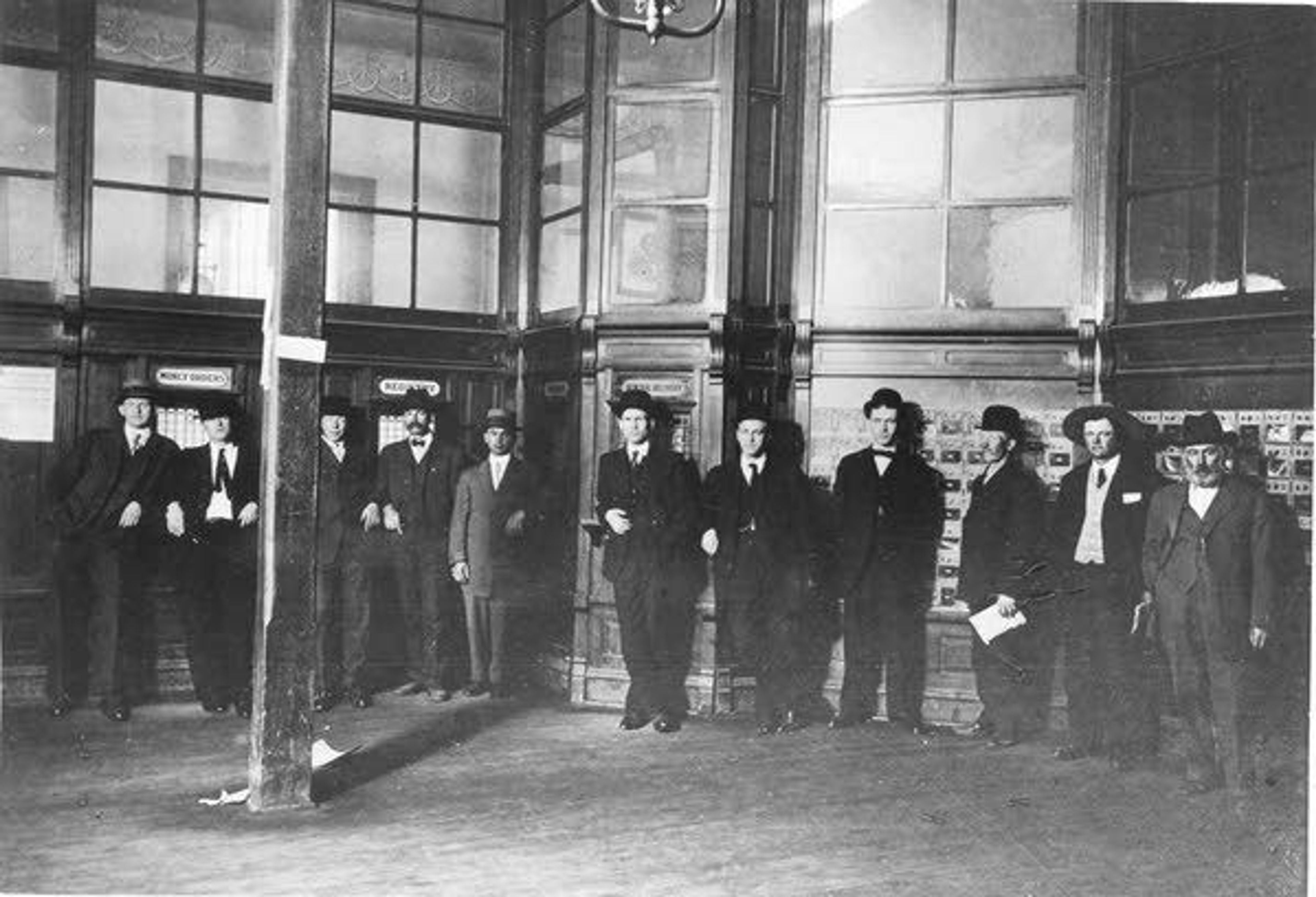 Whitman County Historical SocietyLetter carriers and clerks in the lobby of the Pullman Post Office at 135 Kamiaken St. probably late in King P. Allen’s tenure as postmaster (1902-1914). Left to right: Will Waller, R. M. VanDoren, Clarke Nye, W. H. Latta, A. R. Moore, H. W. Sampson, Ira Allen (Pullman postmaster 1922-1931), Verne Foster, W. H. Tapp, Cliff Parr and postmaster Allen.