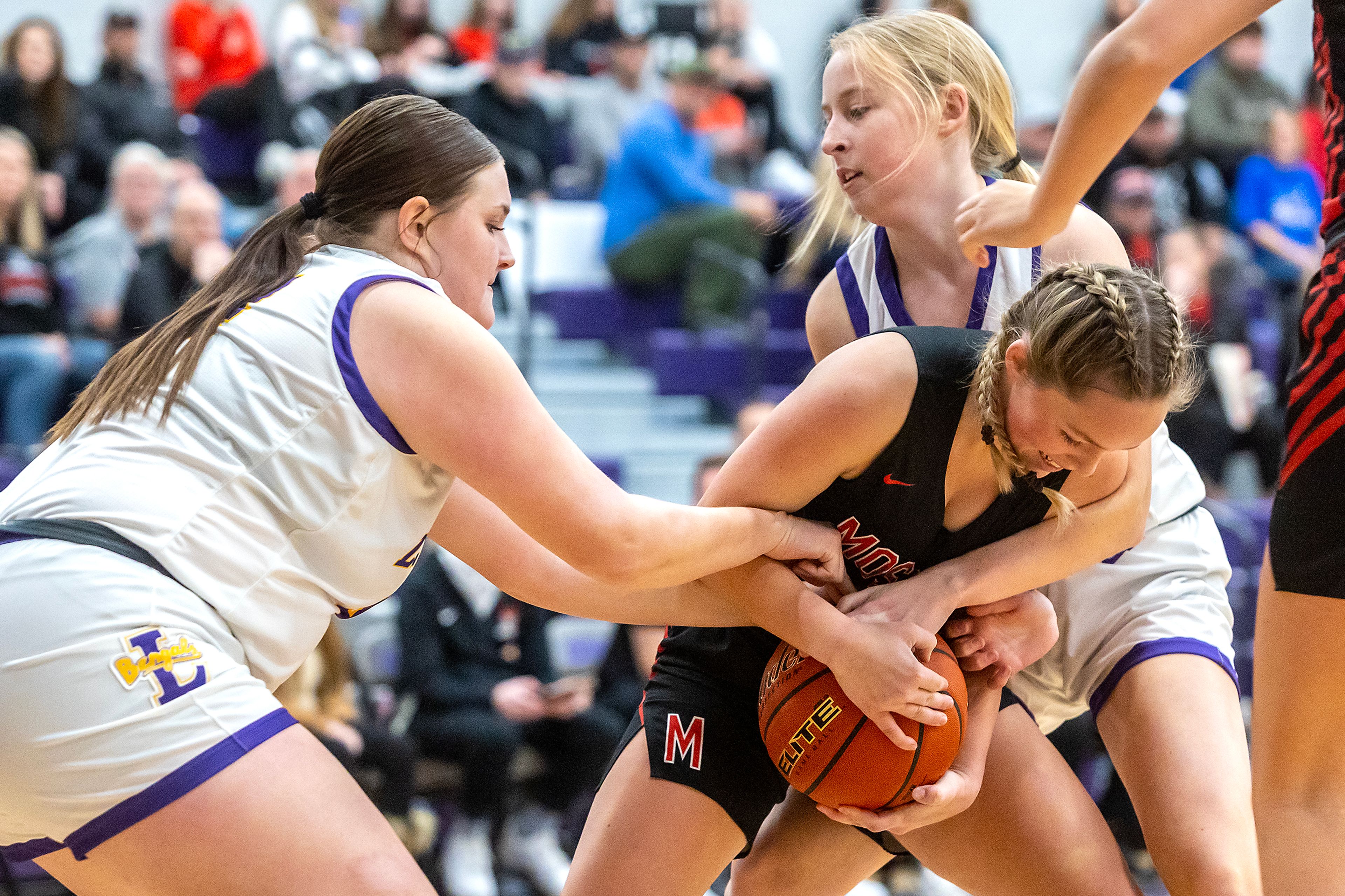 Moscow guard Myah Parsons struggles to keep the ball away from Lewiston point guard Savanah Burkey (left) and guard Dilynn Albright in Lewiston on Wednesday.