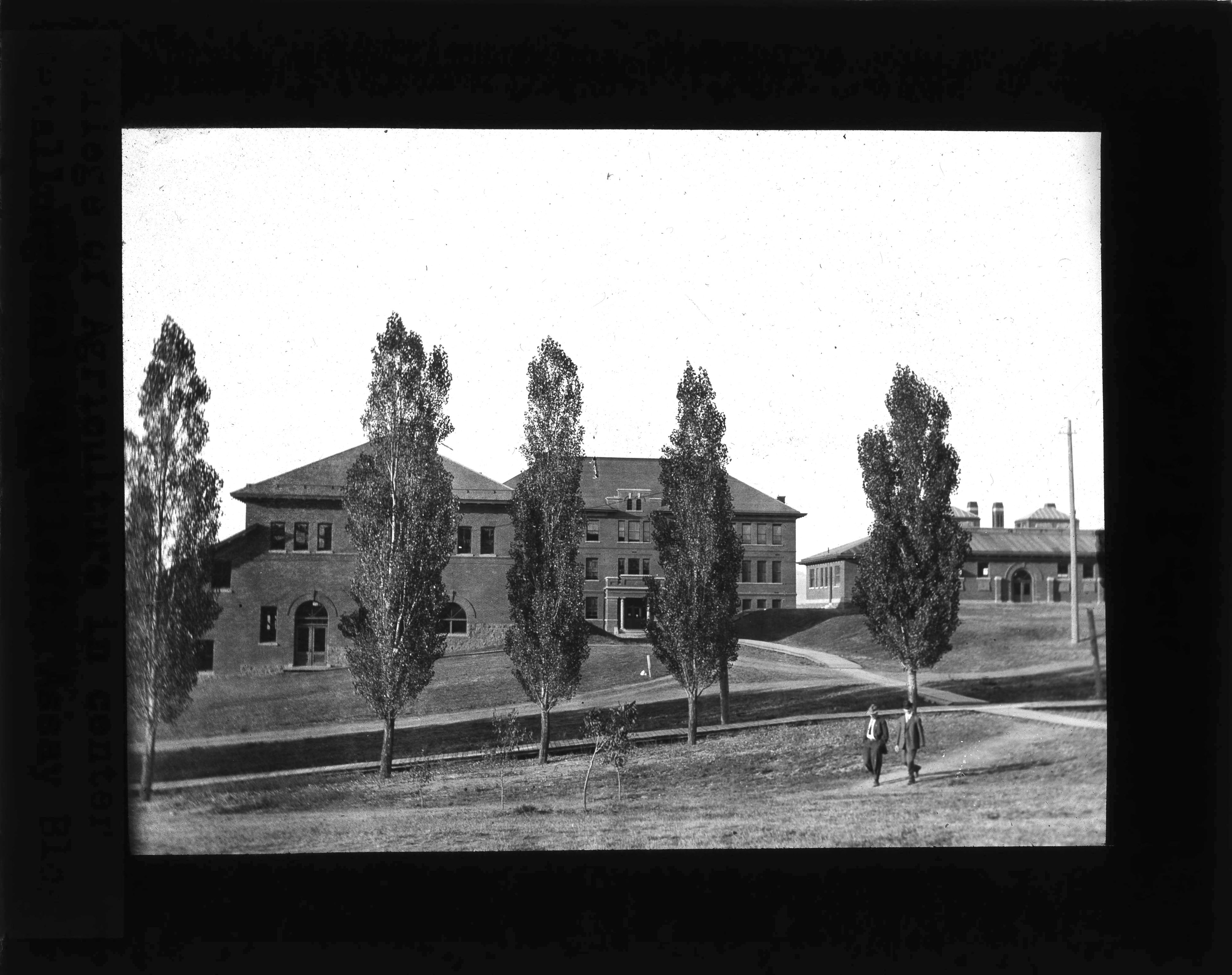 One of Shattuck’s glass lantern slides, a photo of the College of Agriculture building, in the center, and the Metalurgic Mill at left. Dated 1904.