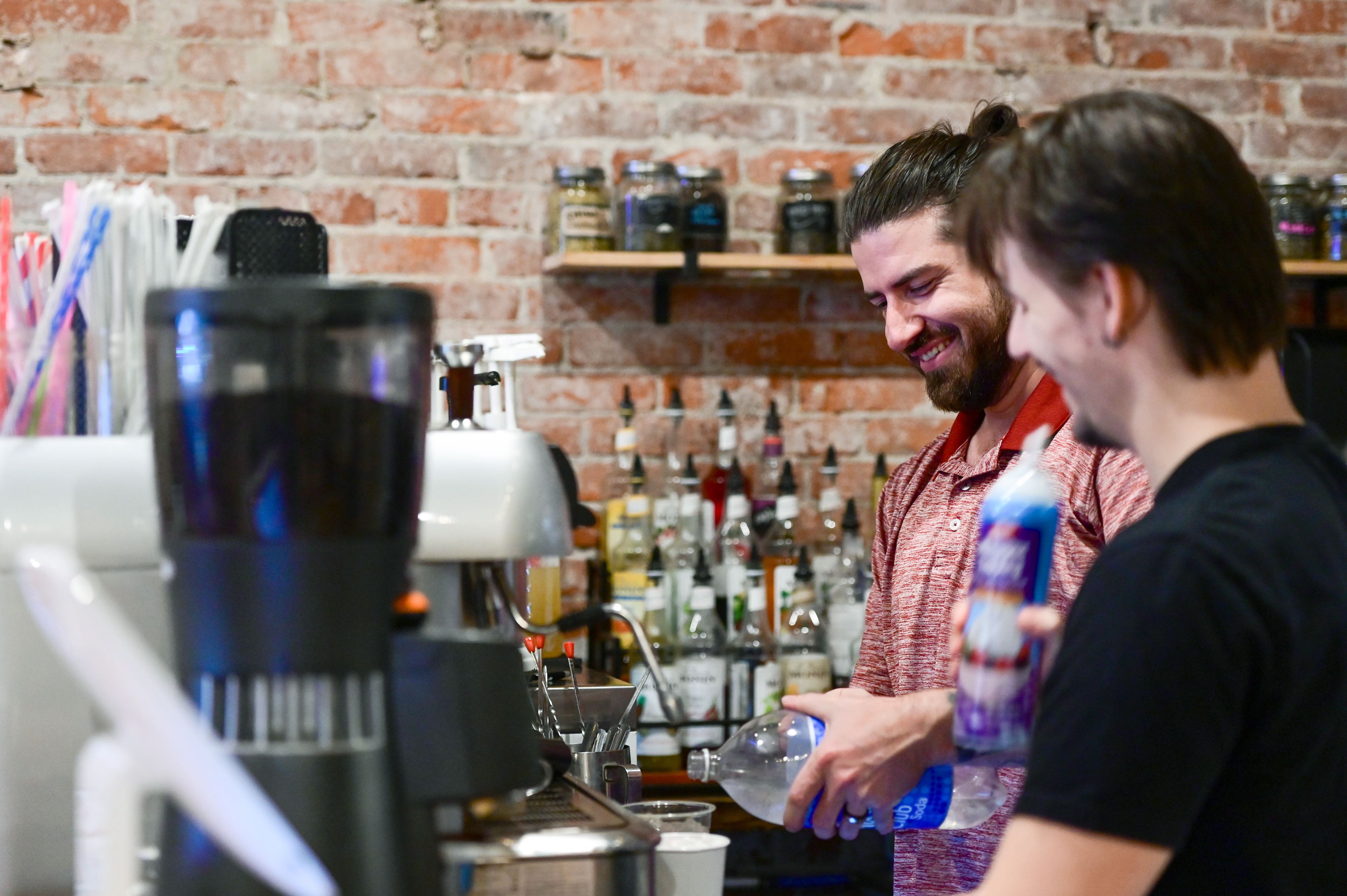 Owner Quincy Robert, left, and Quinn Madsen, right, a manager in training, prepare drink orders behind the counter of Pups & Cups Cafe in downtown Pullman on Wednesday, Nov. 15.