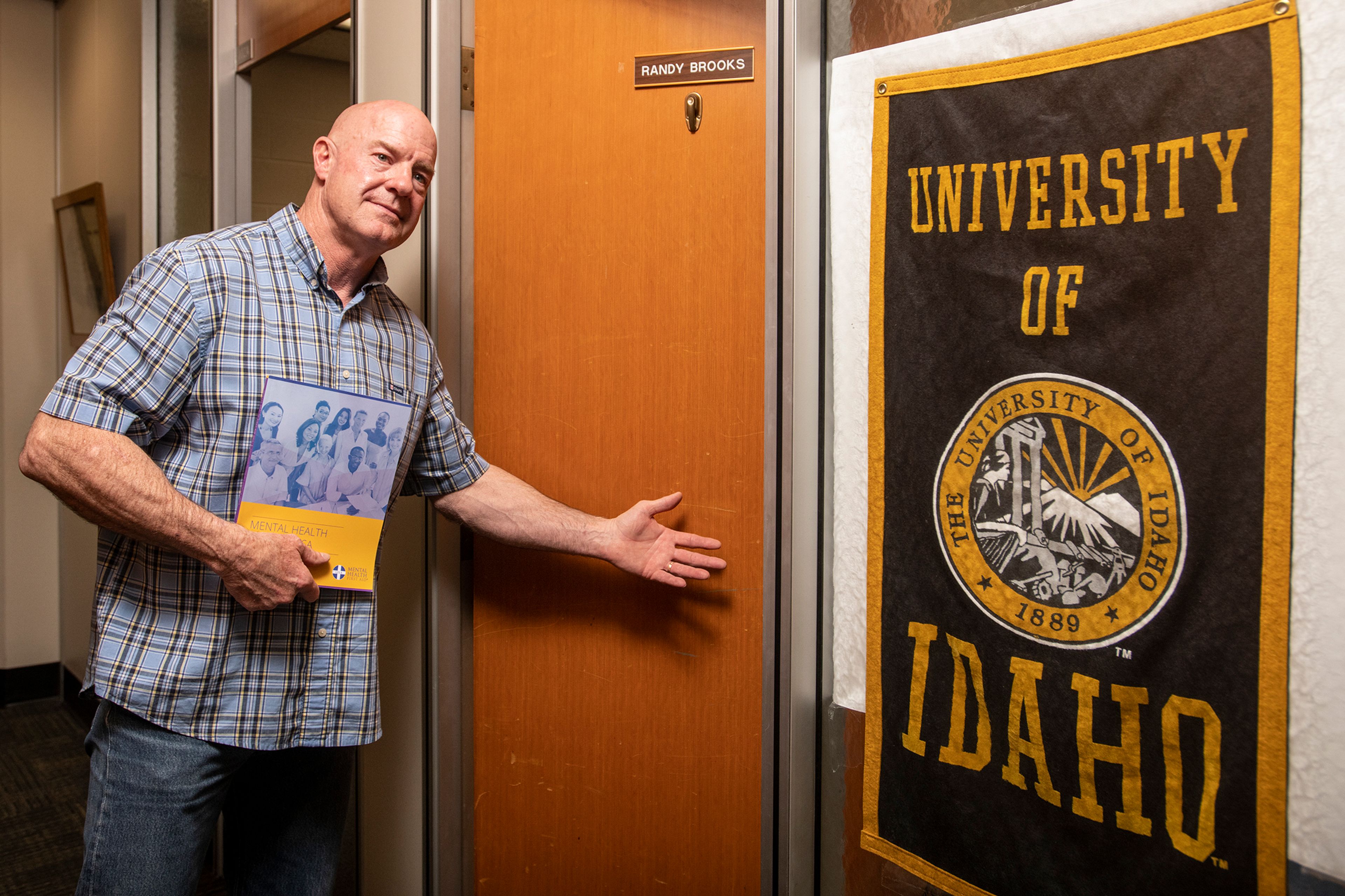 Randy Brooks, a University of Idaho professor and extension forestry specialist, holds a copy of the Mental Health First Aid handbook while posing for a portrait outside his office in the College of Natural Resources building on the Moscow campus. “We all need someone to listen at times in our lives and I just want my students and the people that I work with to know that I’m a safe place to share,” Brooks said. Zach Wilkinson/Daily News