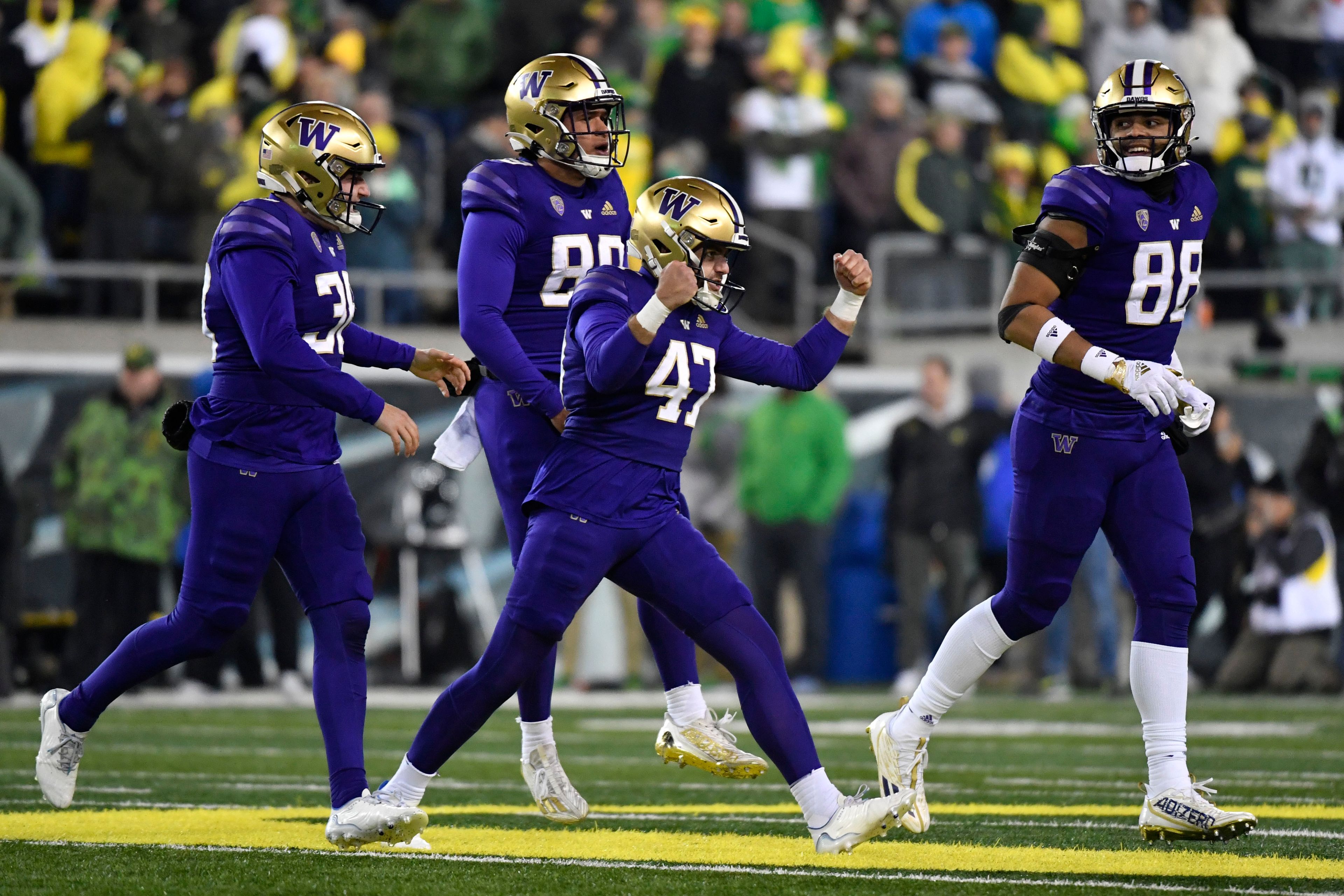 Washington place-kicker Peyton Henry (47) celebrates with punter Jack McCallister (38), tight end Quentin Moore (88) and long snapper Jaden Green (89) after making a field goal during the second half of a game Nov. 12 against Oregon in Eugene, Ore.