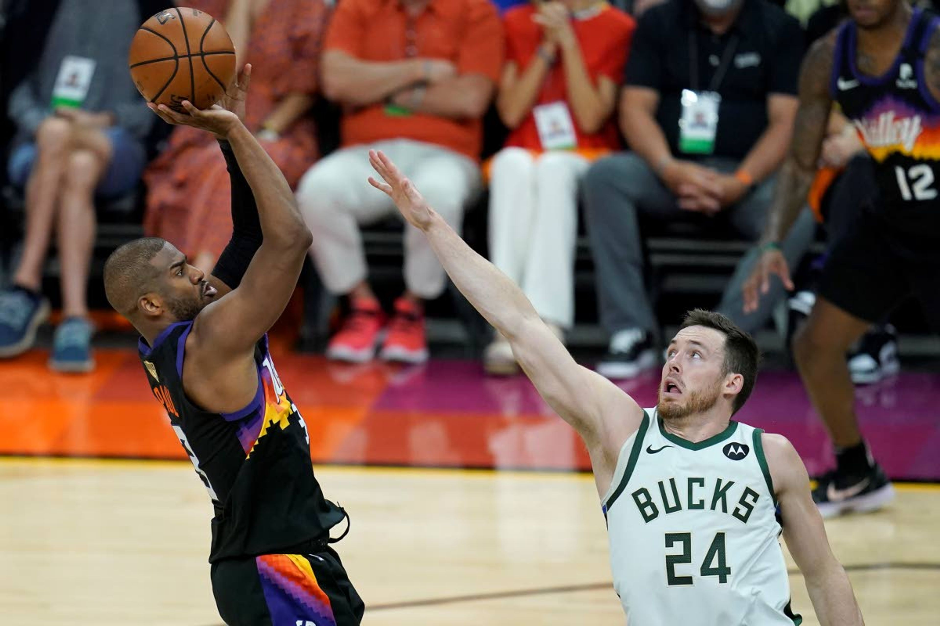 Phoenix Suns guard Chris Paul, left, shoots against Milwaukee Bucks guard Pat Connaughton (24) during the second half of Game 2 of basketball's NBA Finals, Thursday, July 8, 2021, in Phoenix. (AP Photo/Ross D. Franklin)