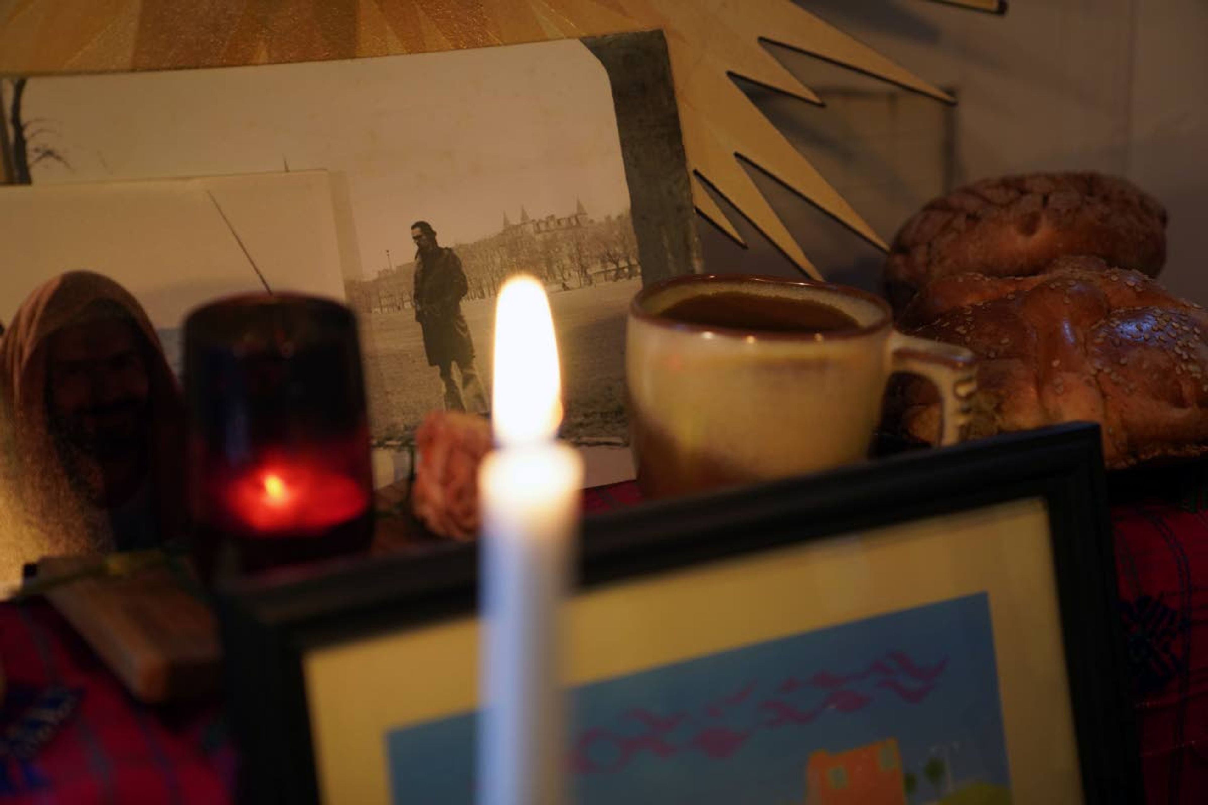 A photograph of Jose Diaz in his 20's sits next to coffee and pan de muerto, two of his favorite things to consume, in a Day of the Dead altar created by his son, Sebastian Diaz Aguirre in the Brooklyn borough of New York, Wednesday, Oct. 28, 2020. "I realized this year in a very special way how important my Mexican roots and this tradition was to me because it has been so comforting," said Diaz Aguirre, who set up his first ofrenda, or altar, since moving to the U.S. eight years ago. (AP Photo/Emily Leshner)