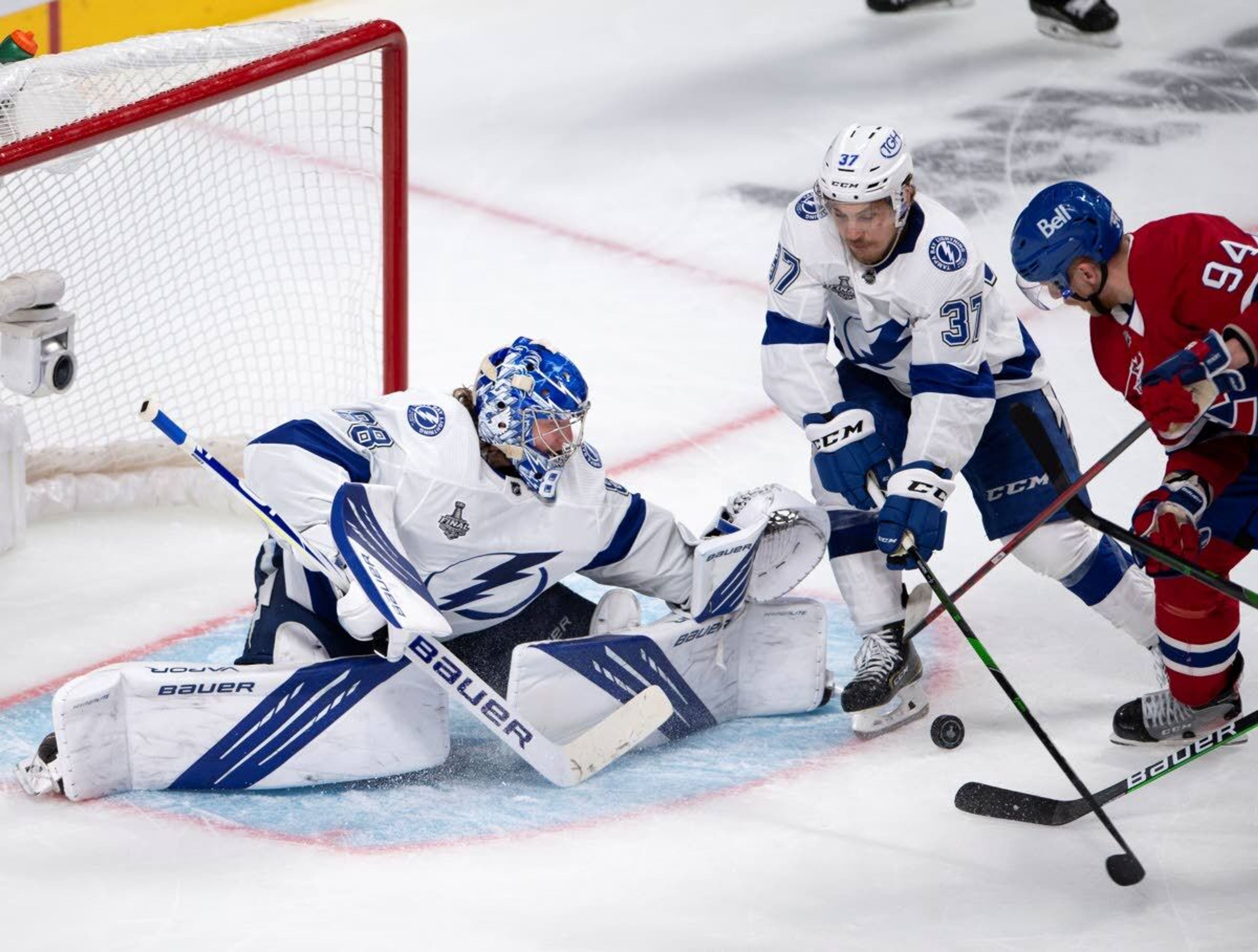 Tampa Bay Lightning goaltender Andrei Vasilevskiy (88) stops Montreal Canadiens right wing Corey Perry (94) as Lightning center Yanni Gourde (37) defends during the third period of Game 3 of the NHL hockey Stanley Cup Final, Friday, July 2, 2021, in Montreal. (Ryan Remiorz/The Canadian Press via AP)