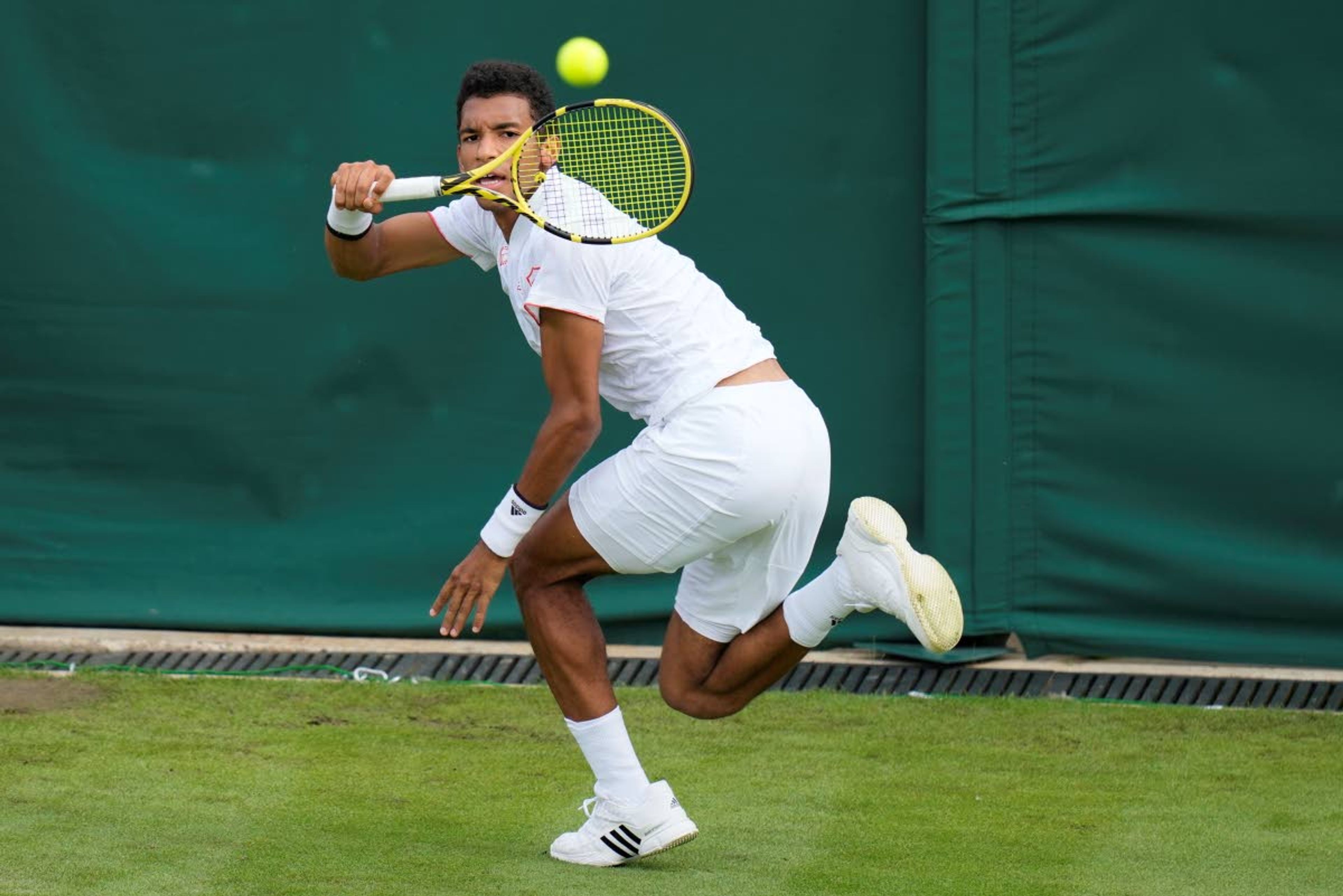 Canada's Felix Auger-Aliassime plays a return to Brazil's Thiago Monteiro during the men's singles first round match against on day three of the Wimbledon Tennis Championships in London, Wednesday June 30, 2021. (AP Photo/Kirsty Wigglesworth)