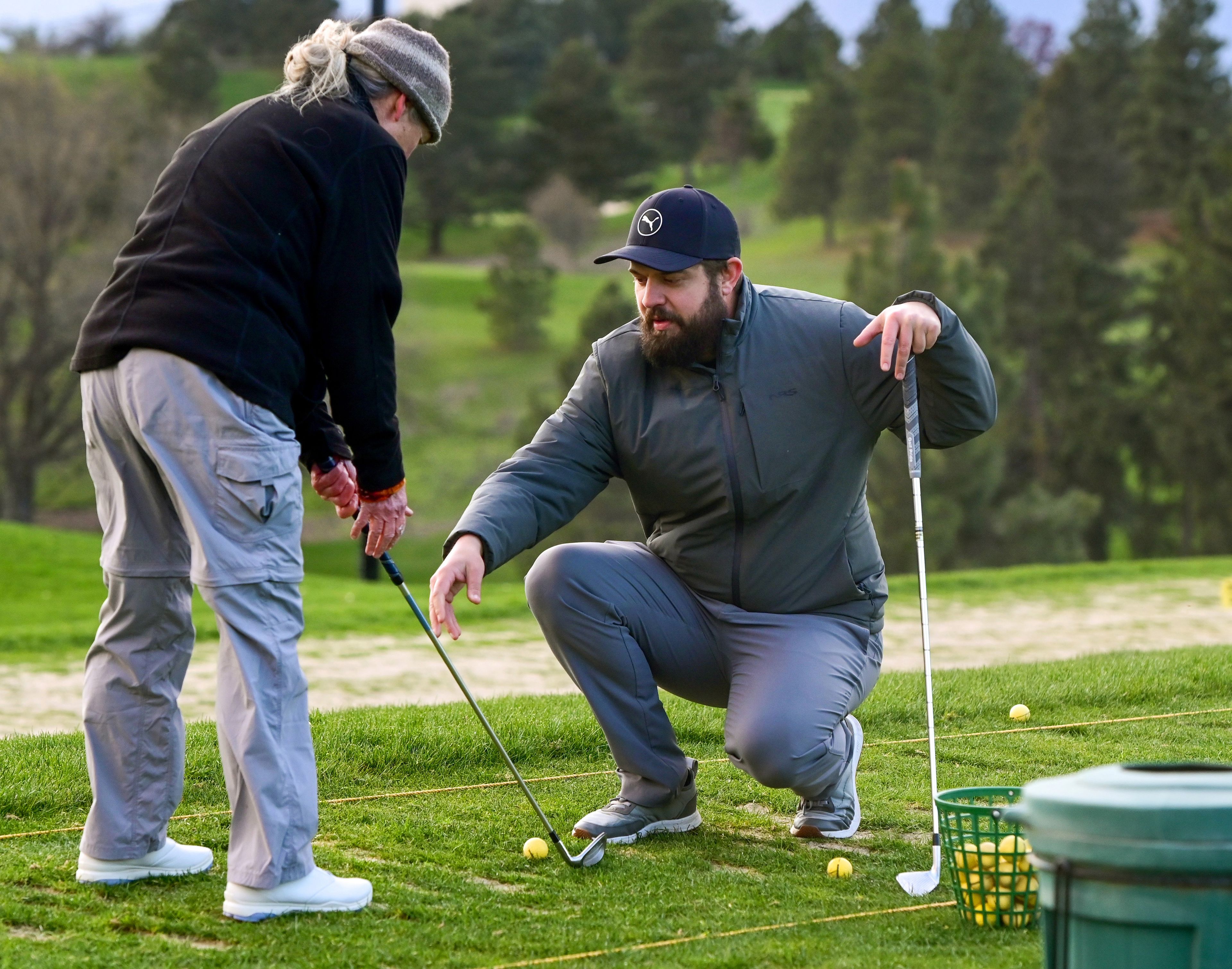 Sarah Rial, of Moscow, is given pointers by Michael Wagner, right, head golf professional at the University of Idaho Golf Course, during an adult women’s class in Moscow on Tuesday.