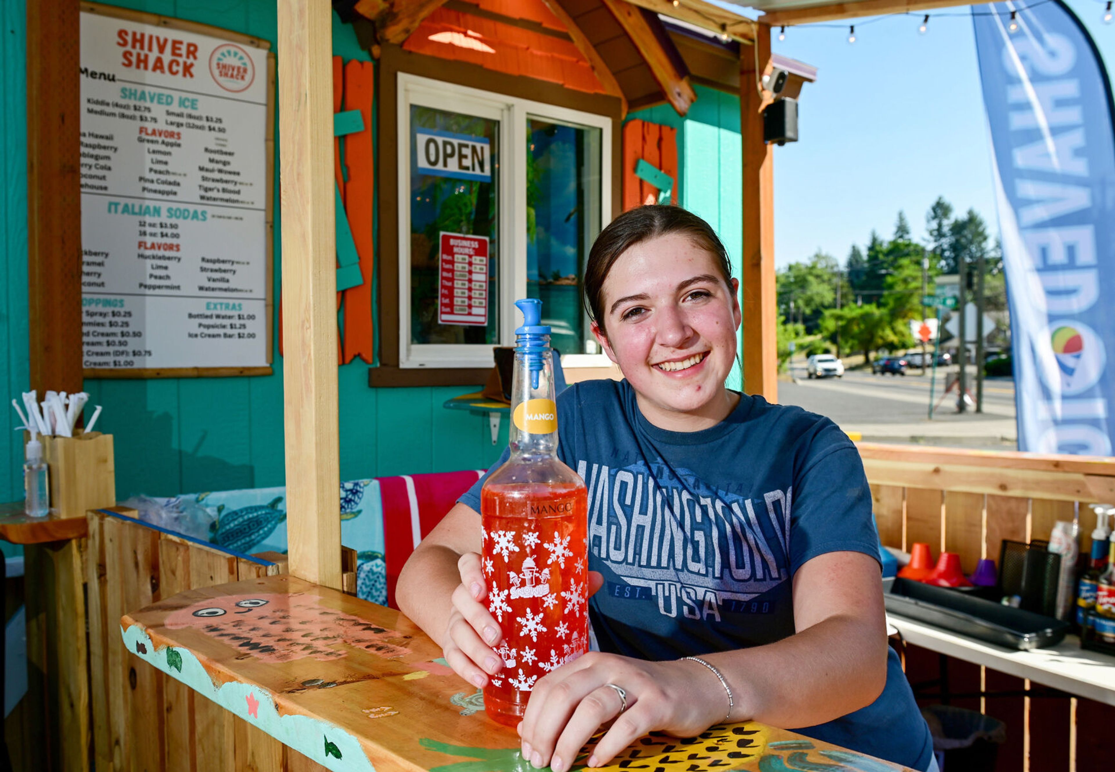 Addyson Fitzgerald, 15, manager of the Shiver Shack, holds a syrup bottle at the new snow cone spot in Pullman on Tuesday.