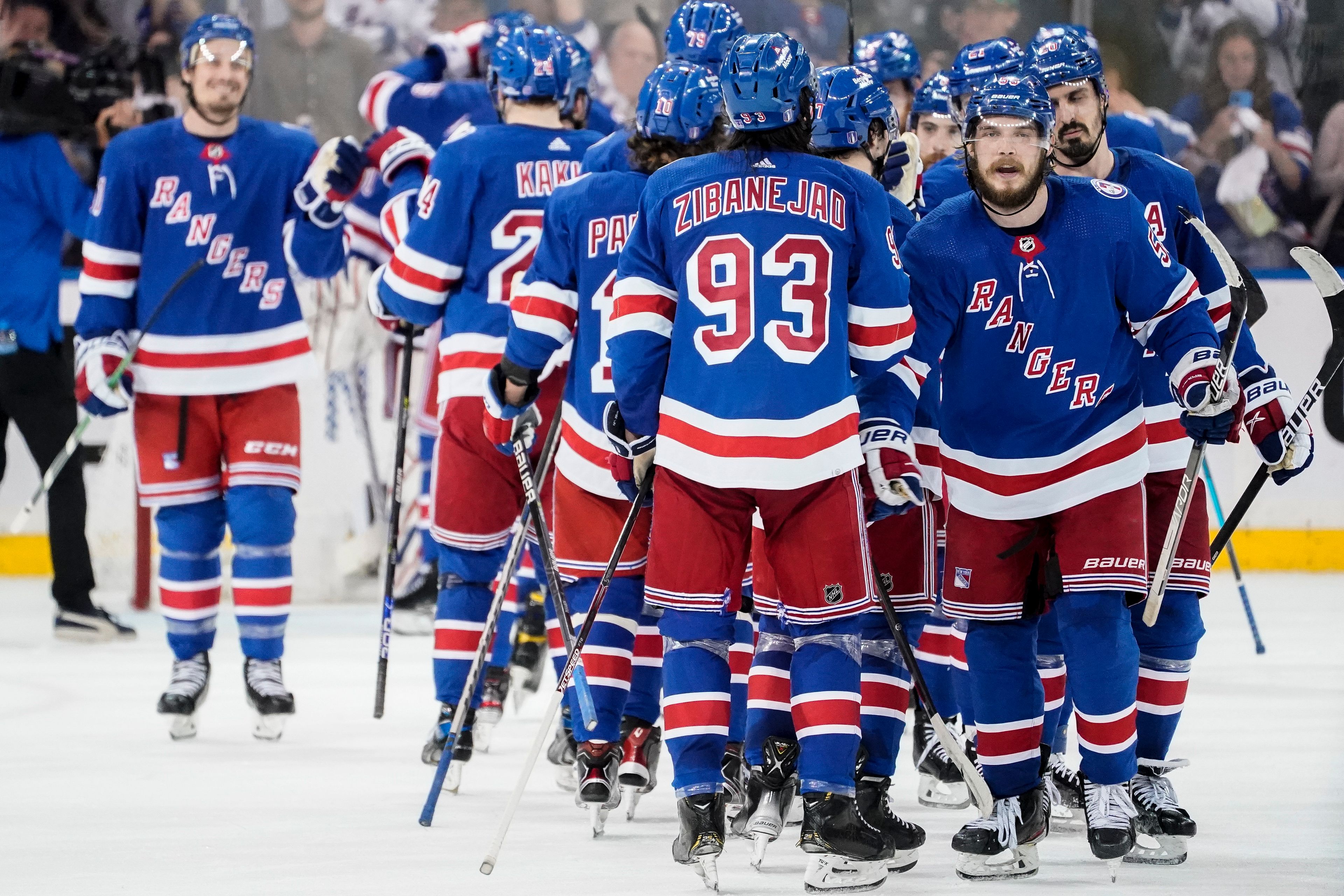 New York Rangers defenseman Ryan Lindgren (55) and center Mika Zibanejad (93) celebrate after Game 2 of the NHL hockey Stanley Cup playoffs Eastern Conference finals against the Tampa Bay Lightning, Friday, June 3, 2022, in New York. (AP Photo/John Minchillo)