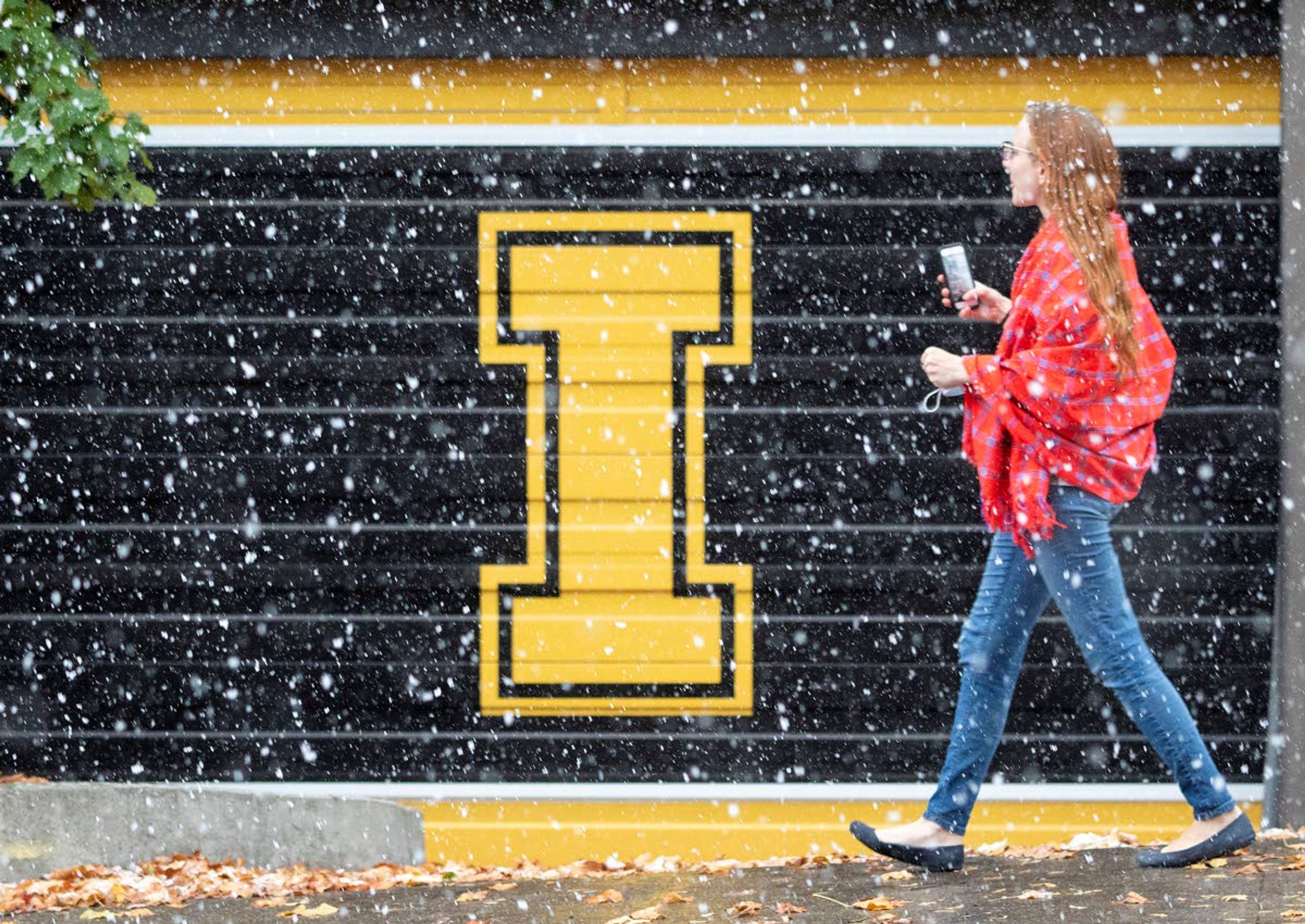 A woman walks across the University of Idaho campus during a snow storm on Friday in Moscow.