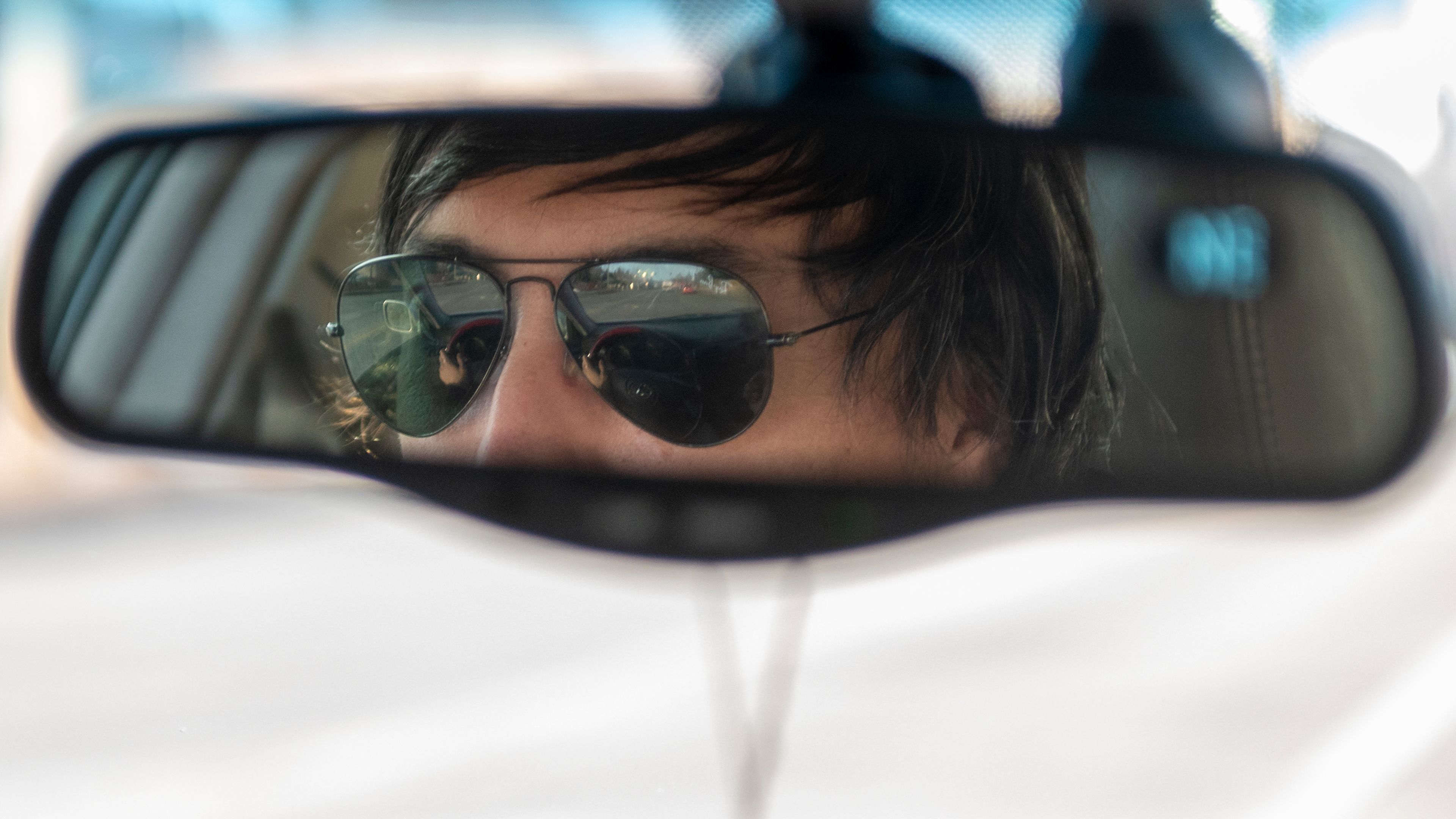 Pullman’s Grand Avenue is reflected in Frank Contreras’ sunglasses as he drives through town picking up delivery orders. Contreras is seeking asylum in the U.S. and is not undocumented.