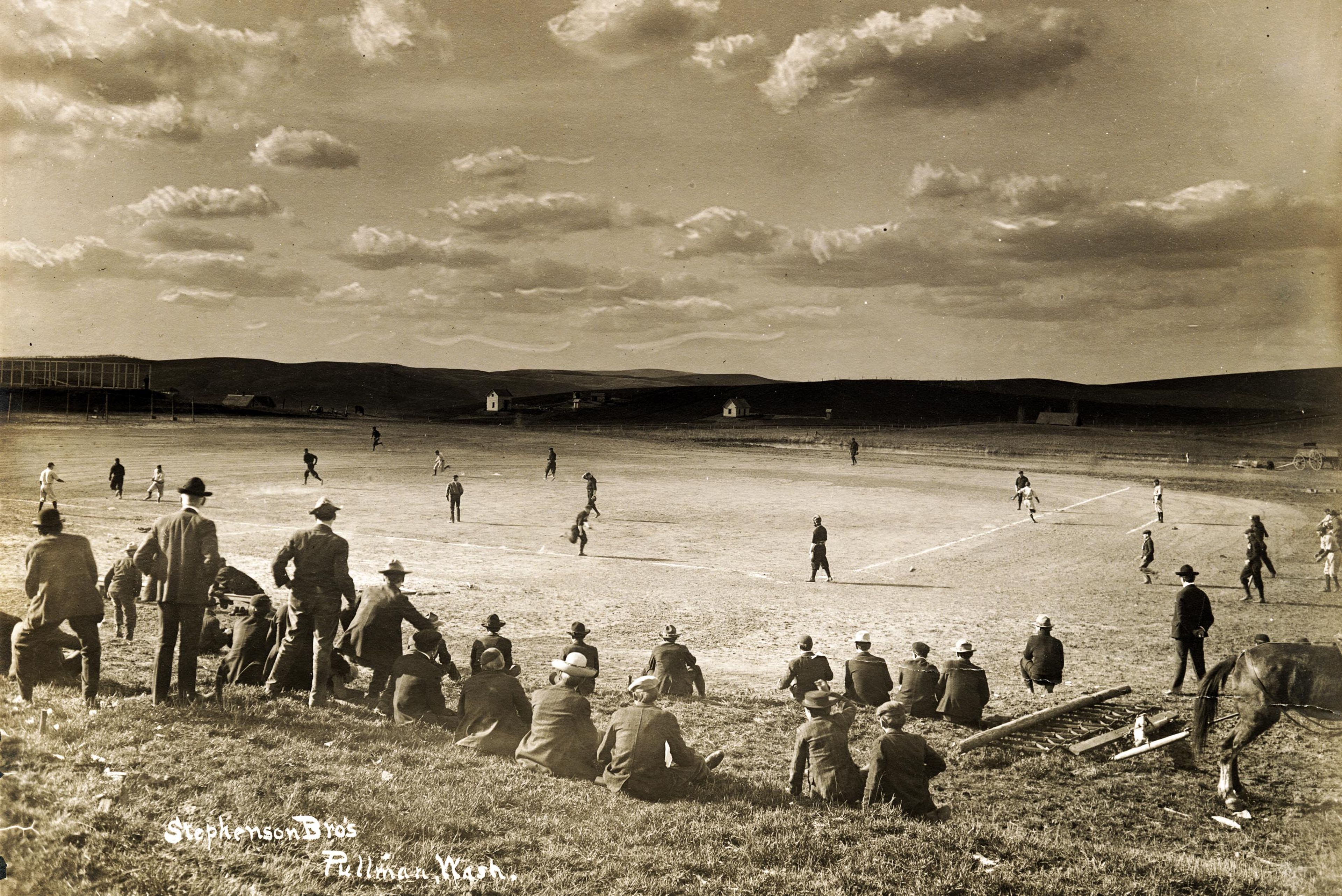 Looking northeast at a Washington State College baseball game being played under dramatic clouds. This is likely about 1906-1910, from what is today downhill from the west end of the CUB.